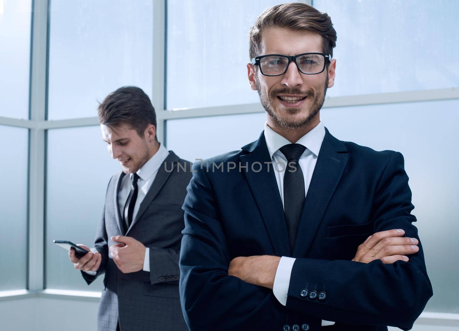 Businesspeople using technology in busy lobby area of office by asdf