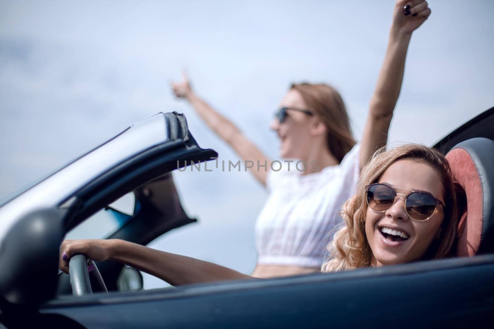 close up.two girlfriends traveling in a convertible car by asdf