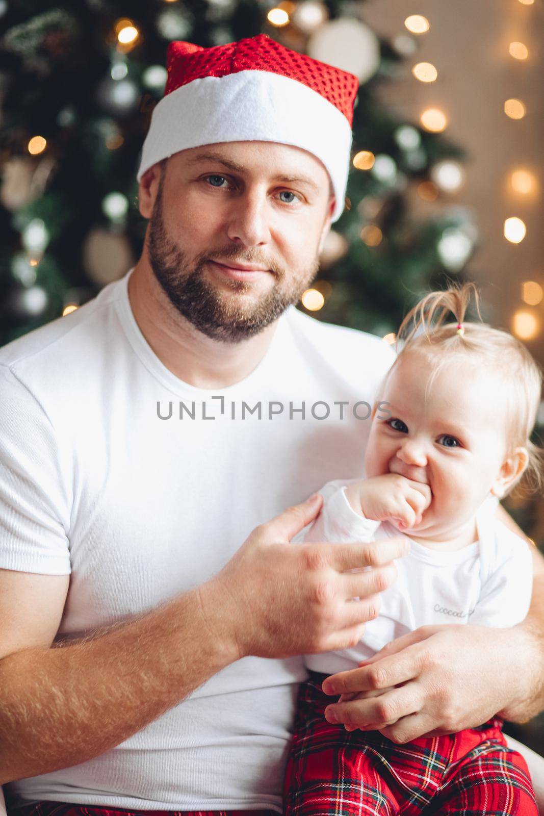 Father in Santa hat with daughter. by StudioLucky