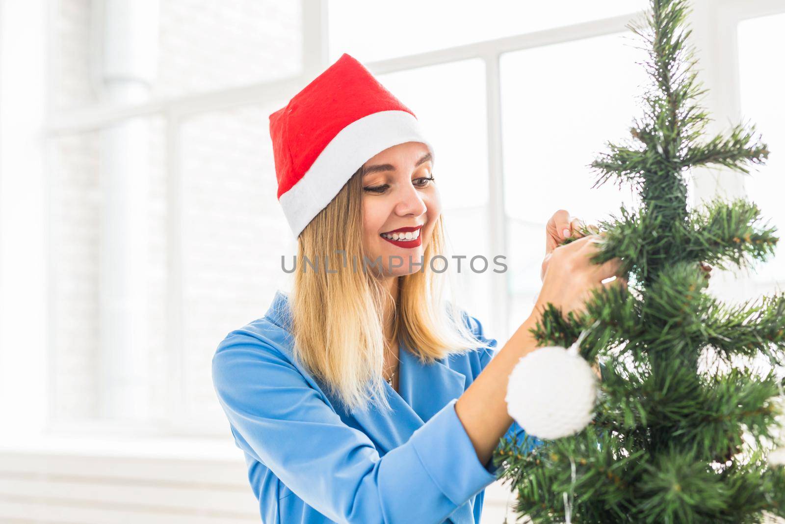 winter holidays, celebration and people concept - close up of woman decorating christmas tree with ball