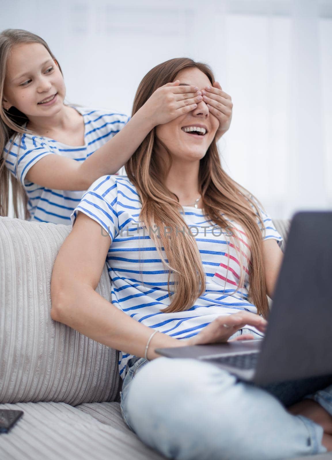 guess who. little girl closing her eyes to her mom . the concept of family happiness