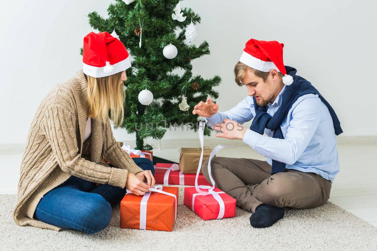 Holidays, family and festive concept - Couple with Christmas gifts at home.