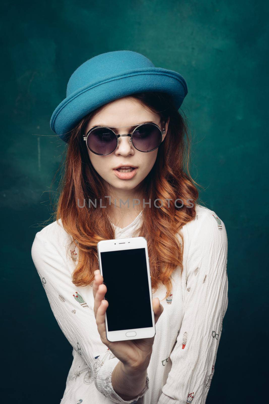 fashionable woman in blue hat with phone in hands communication technology. High quality photo