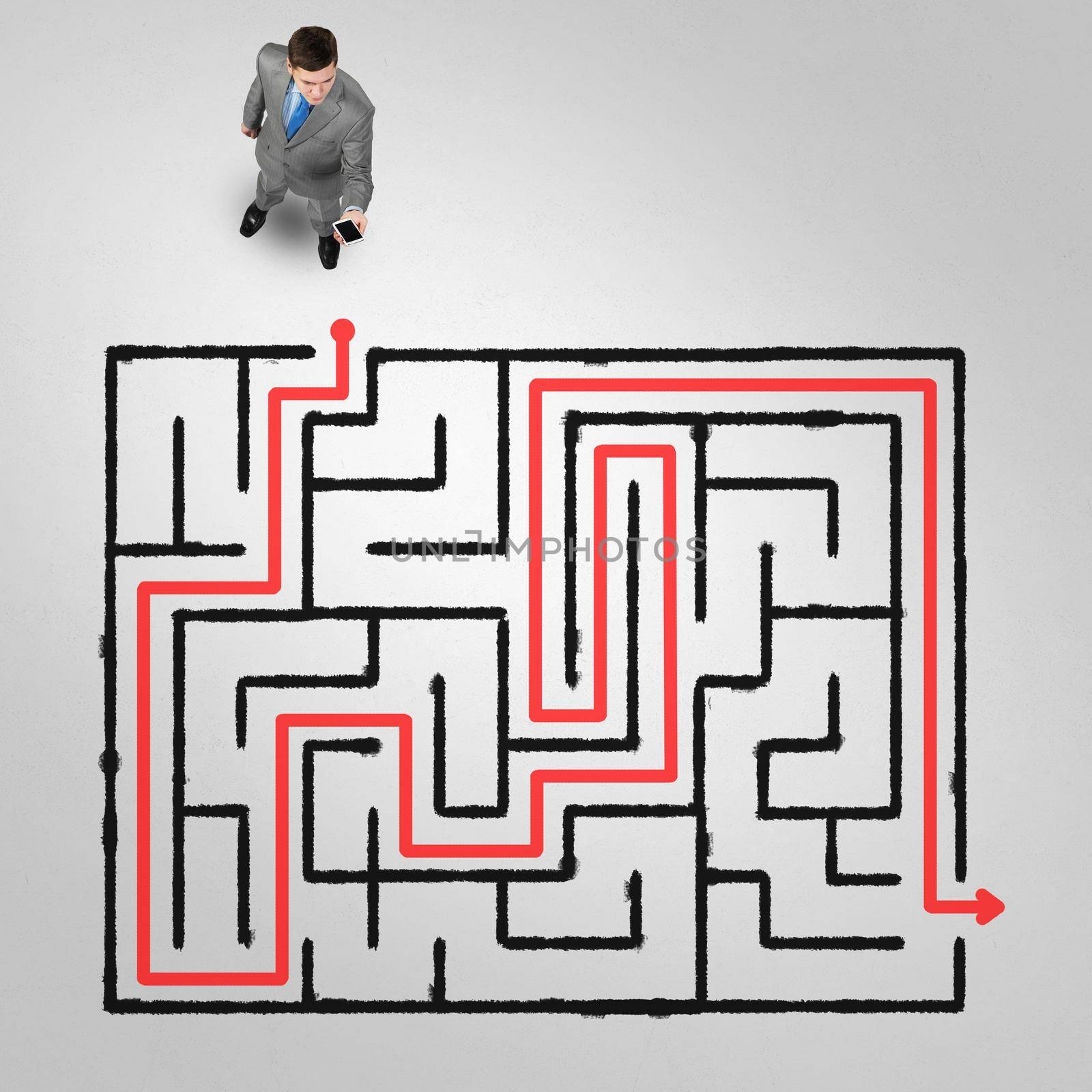 Top view of puzzled businessman looking at drawn maze on floor