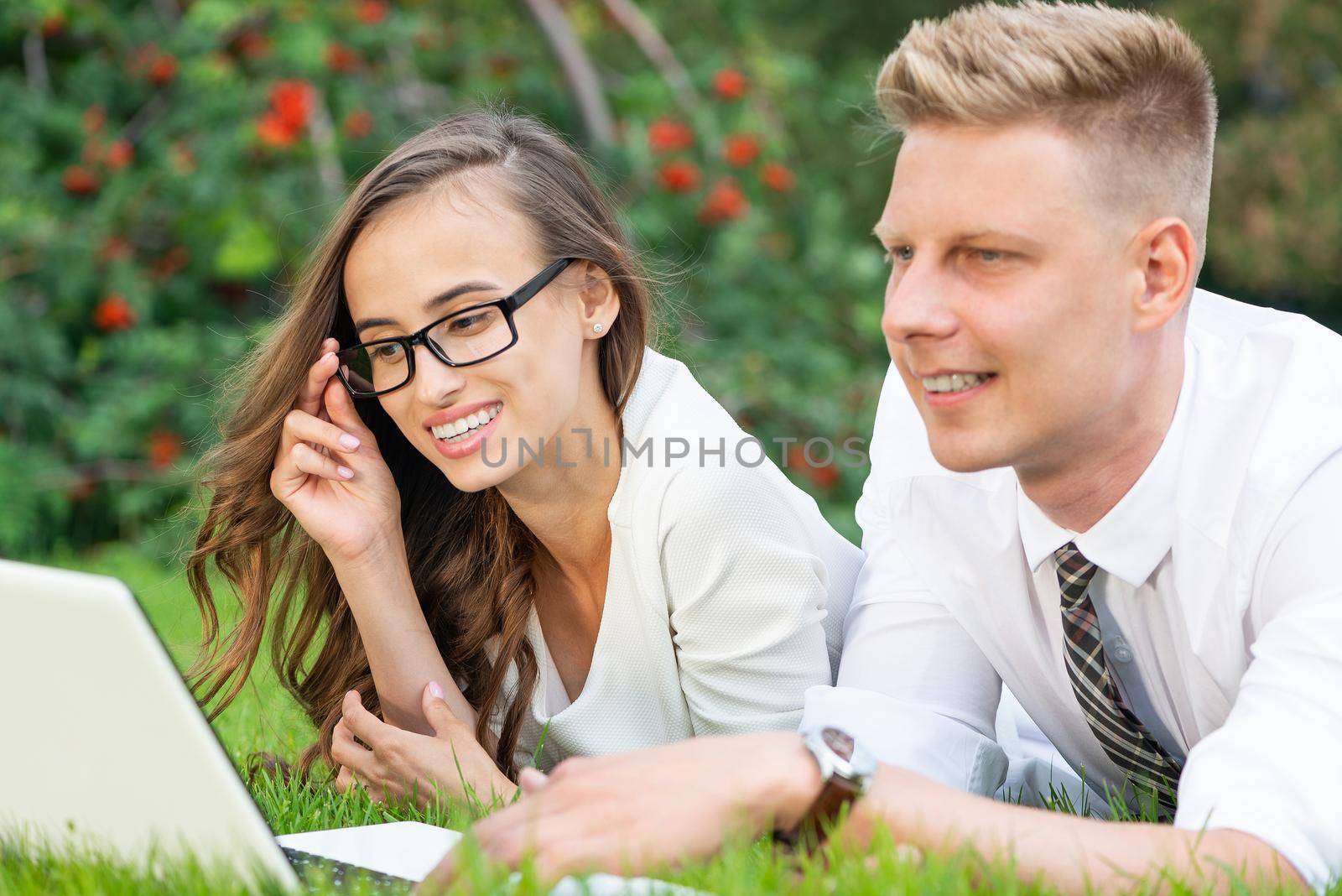 businessman and businesswoman with a laptop in a city park by adam121