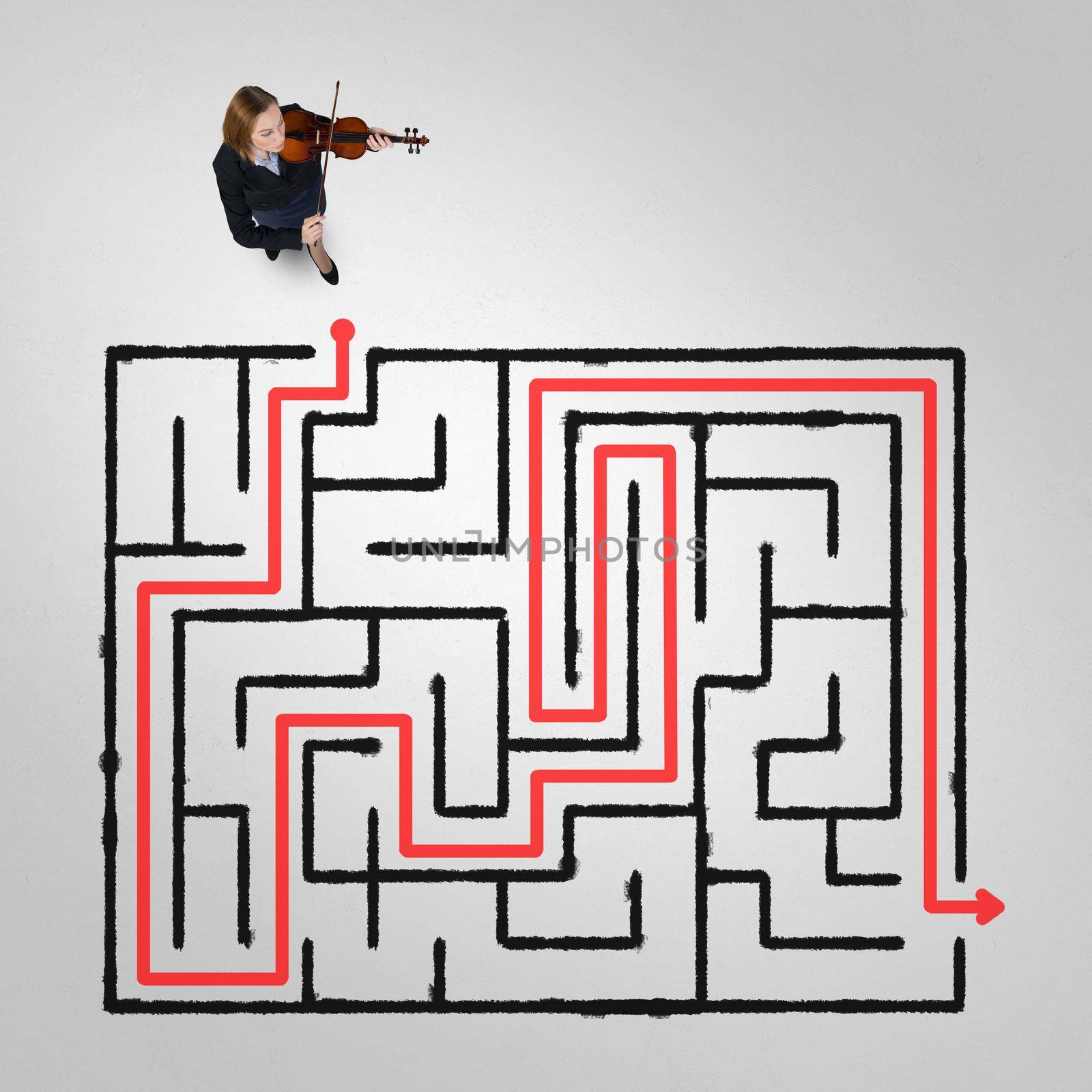 Top view of businesswoman playing violin and drawn labyrinth on floor