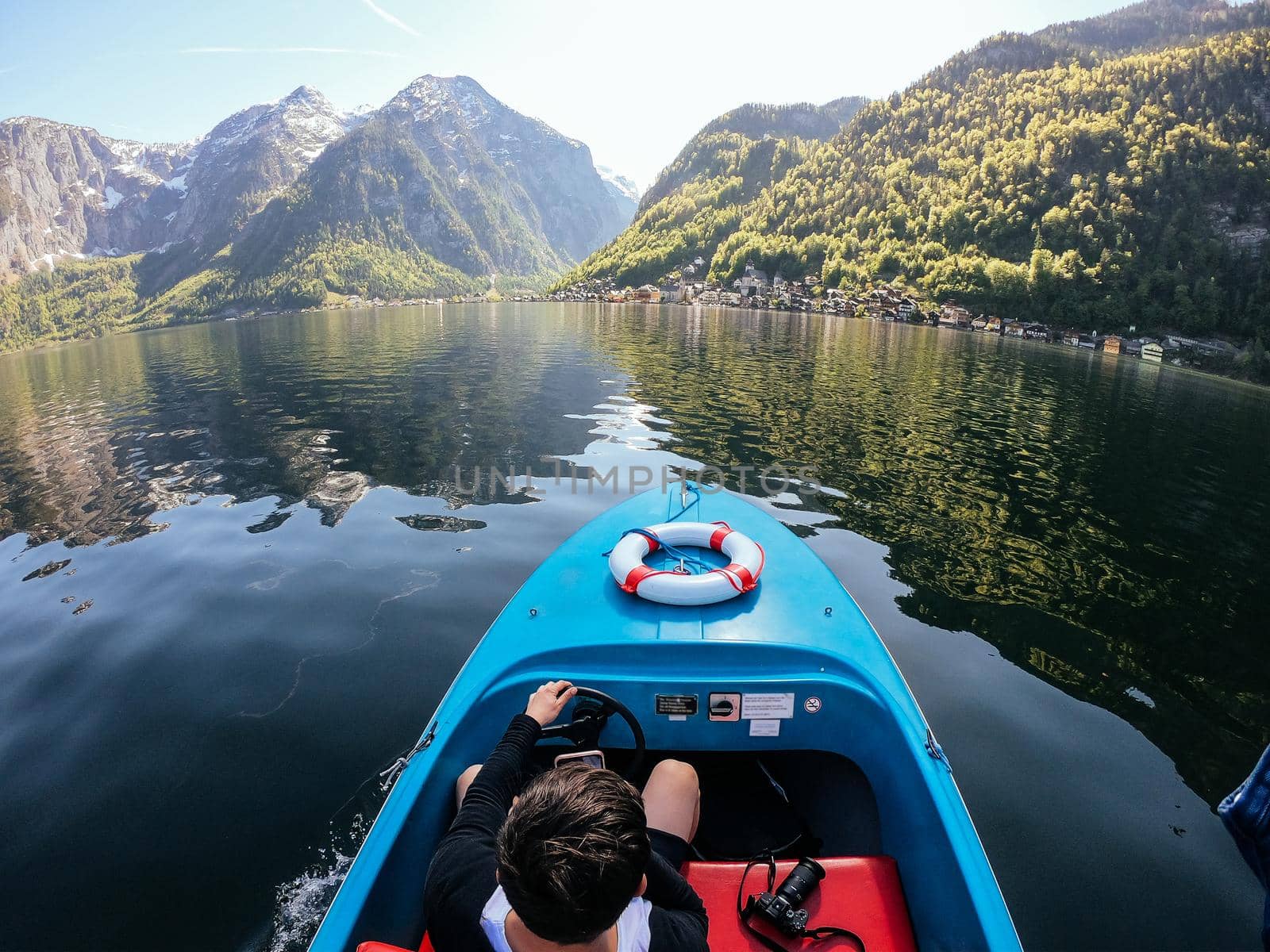 Guy controls a motorboat on a mountain lake