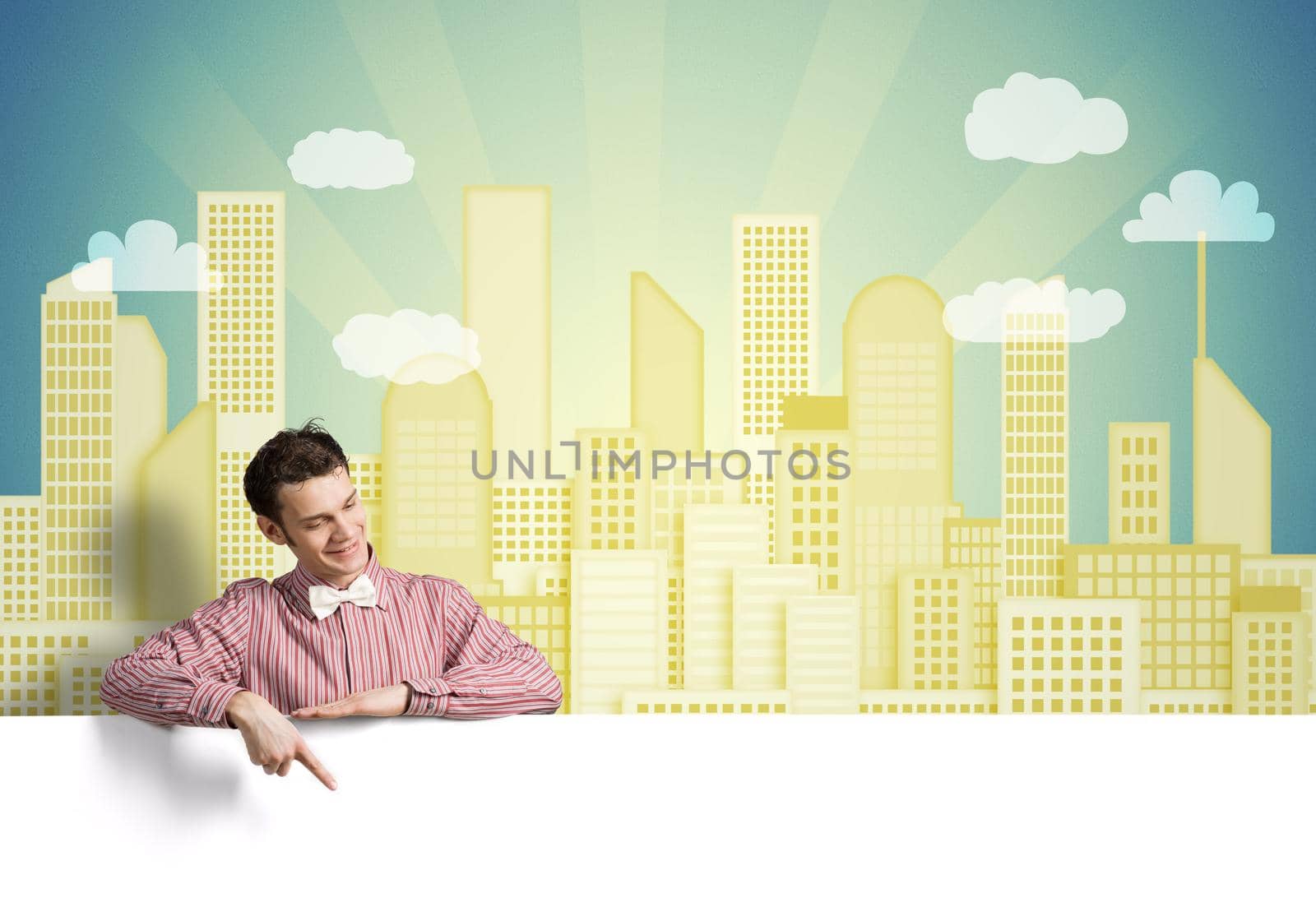 Young funny guy in checked shirt pointing with finger at blank banner