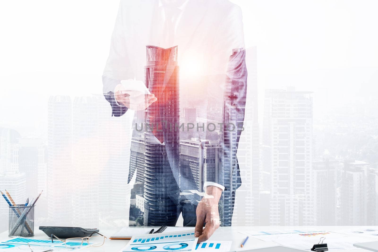 Businessman standing near office desk and using smartphone. Online stock trading and investment. Corporate manager in suit and tie working with business analytics. Entrepreneurship and leadership.