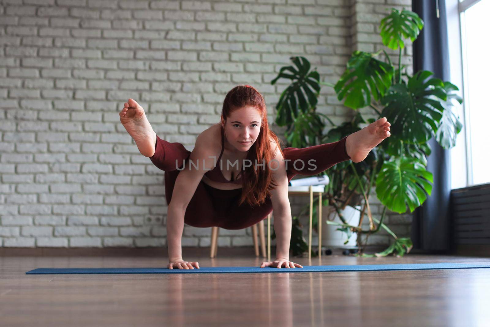 Healthy life. Attractive woman practicing home yoga, working out, wearing sportswear