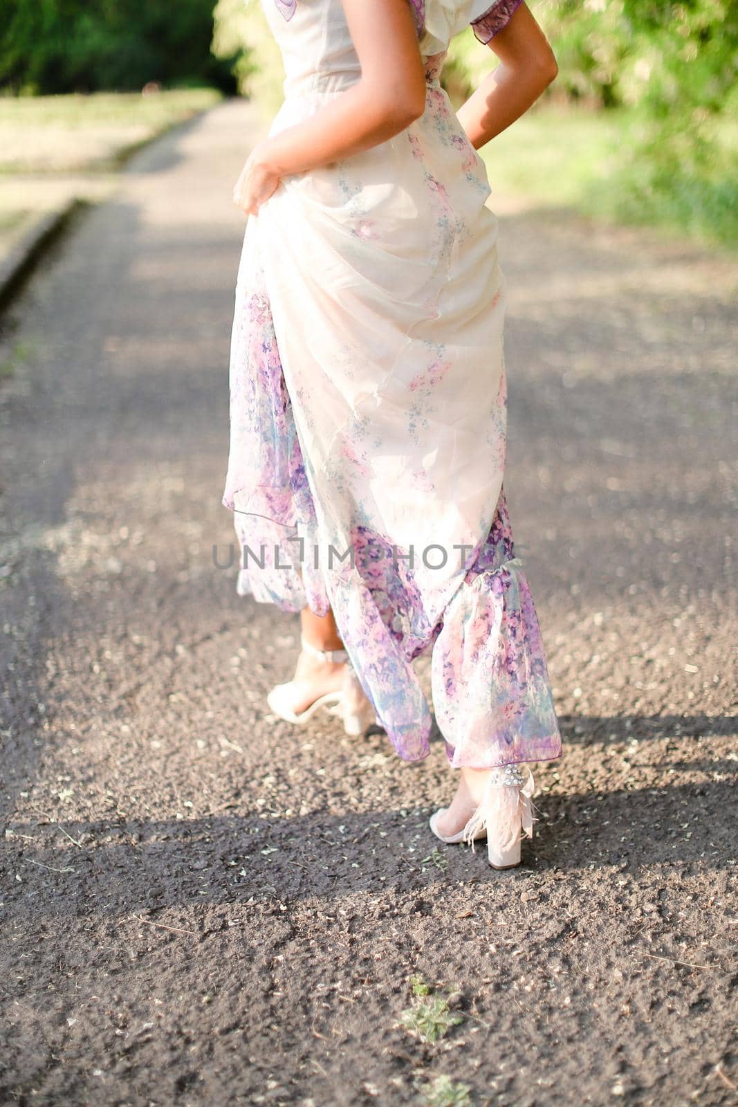 Back view of girl wearing white dress walking outside. Concept of spring inspiration.