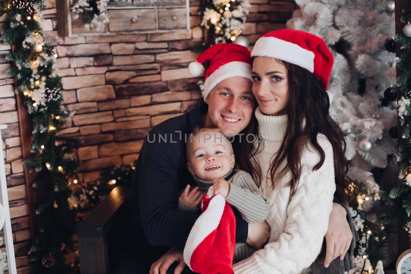 Happy beautiful caucasian family smiles together with christmas hats
