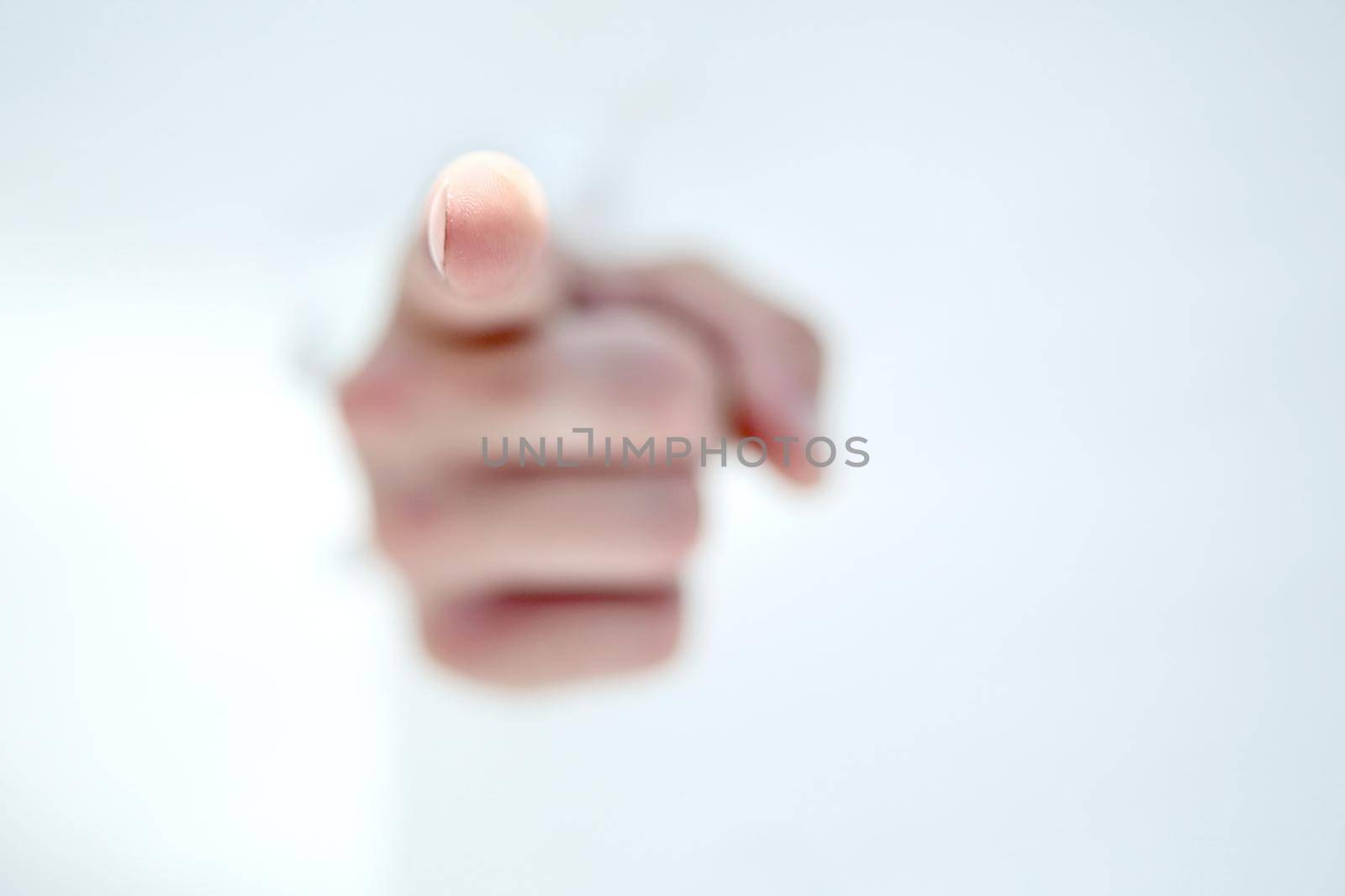 man's hand breaking through the paper wall and pointing at you .photo with copy space