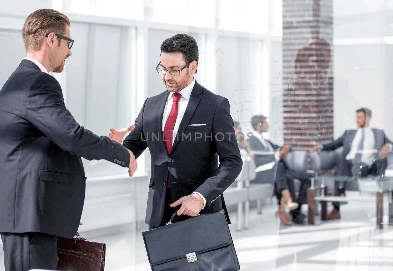 Portrait of two happy businessmen handshaking after striking promising deal