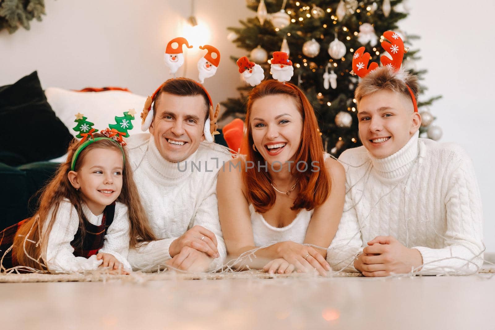 Close-up portrait of a happy family lying near a Christmas tree celebrating a holiday.