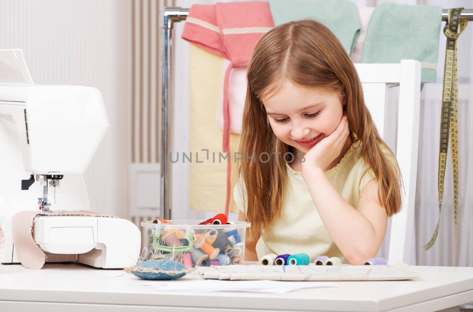 Little female pupil working with various coil threads