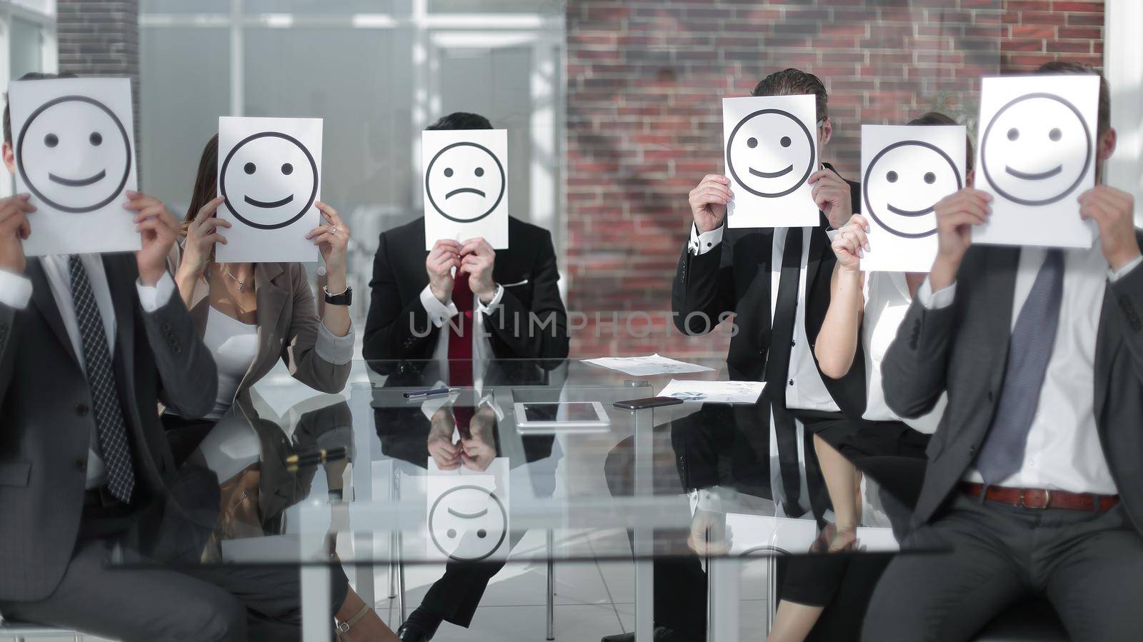 business team with smiley icons sitting at the Desk.business concept