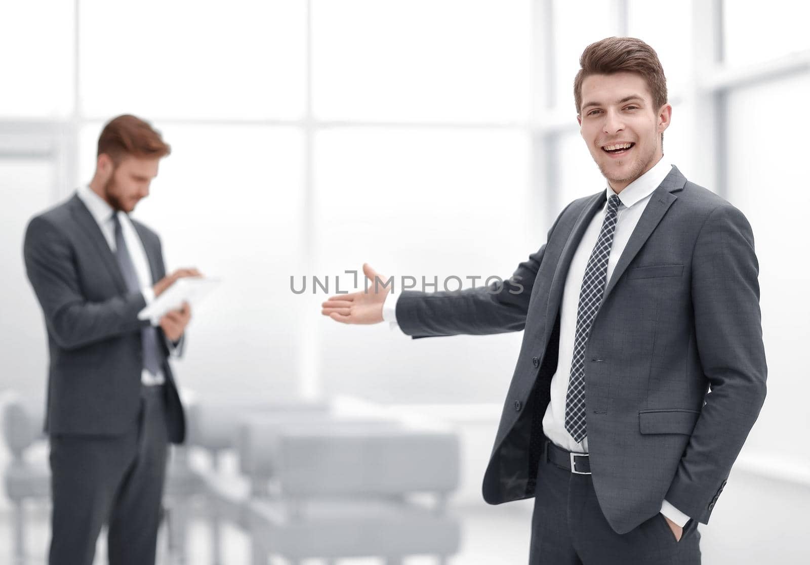 Young businessman invites to his office.photo with copy space
