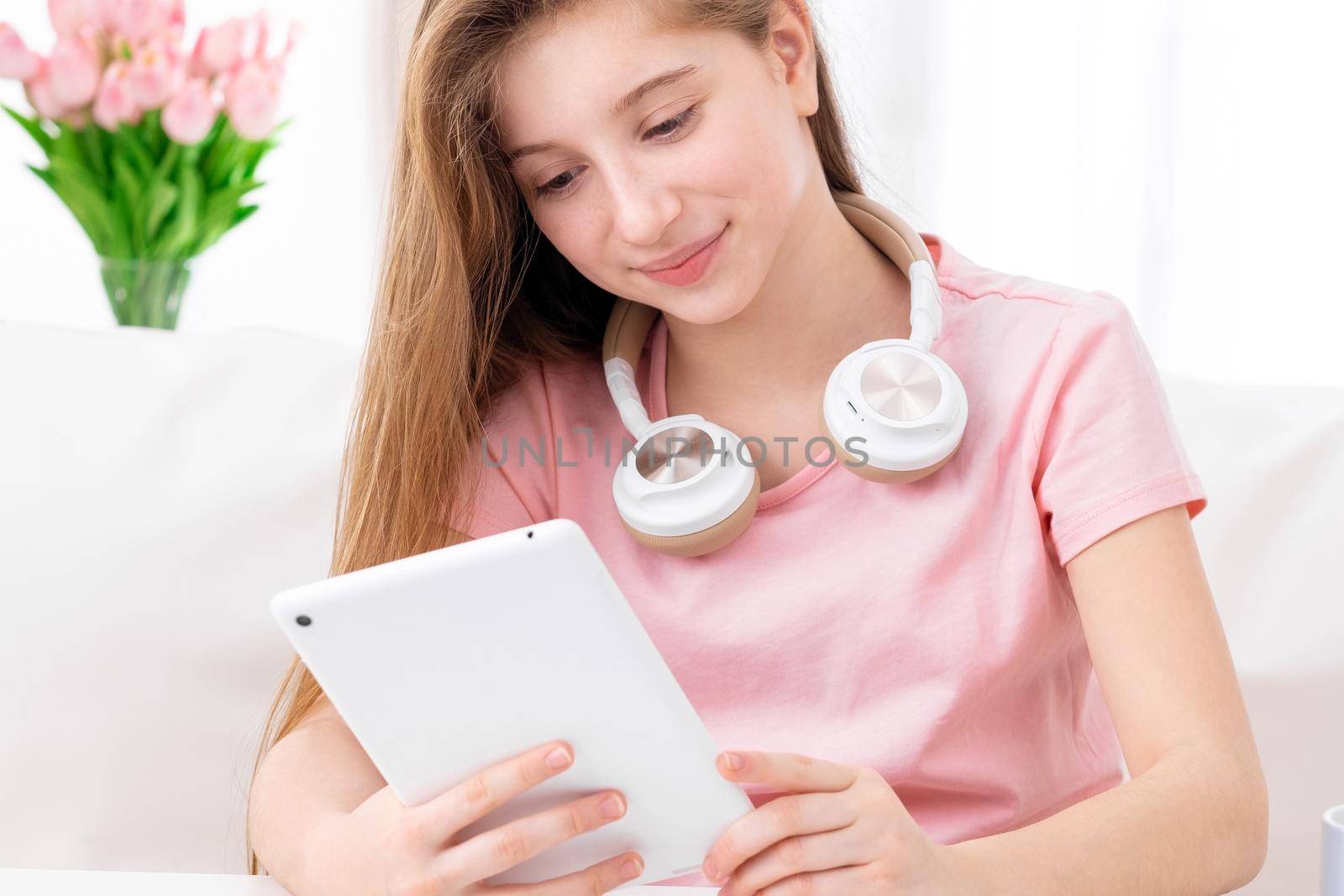 cute teen, browsing interesting articles on internet on her personal tablet computer