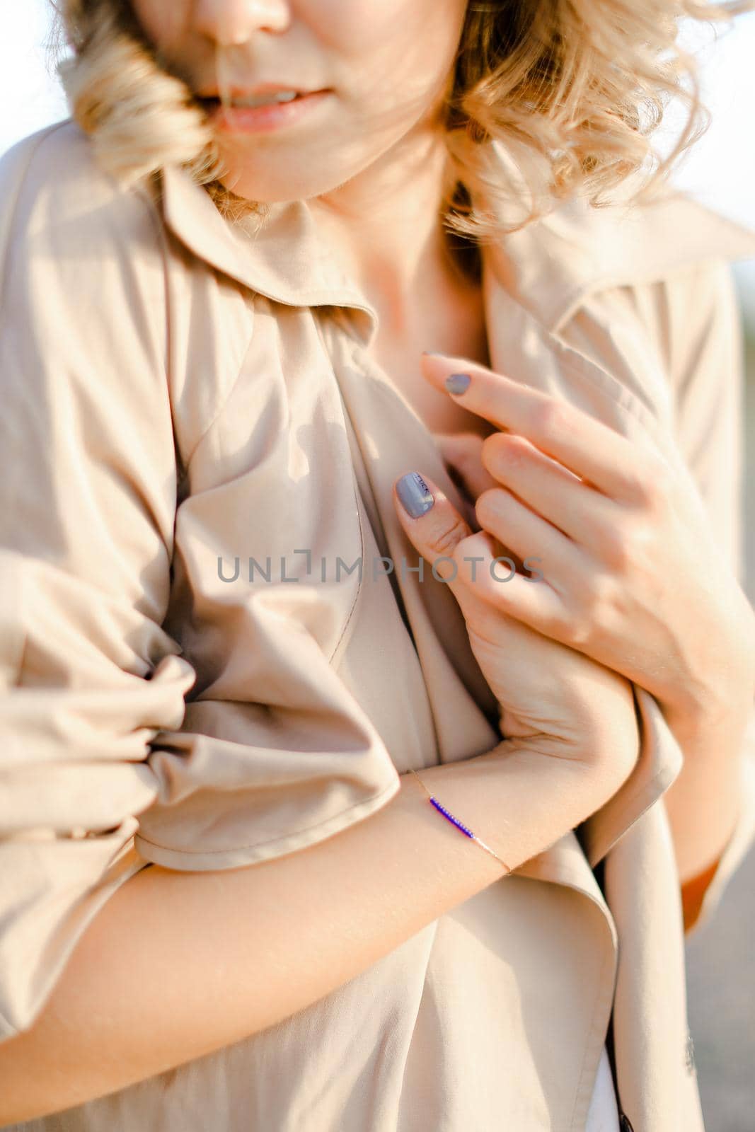 Close up woman with manicure and without makeup wearing coat. Concept of spring fashion and beauty.