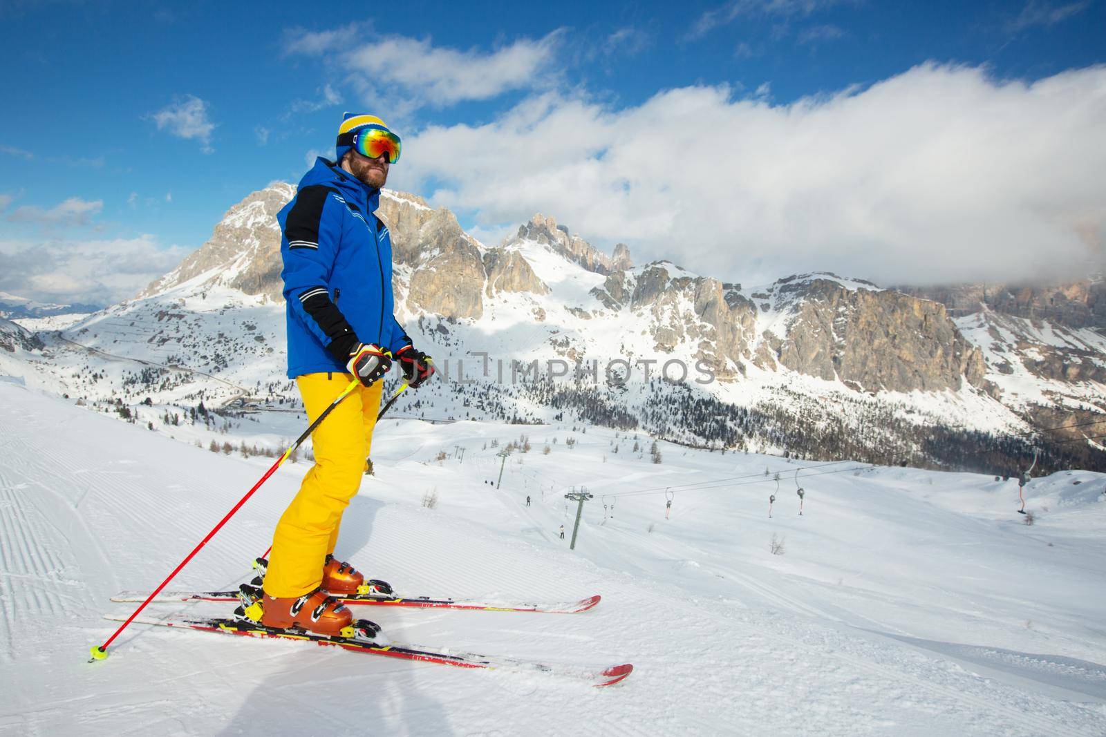 Alpine skier stand on slope in winter mountains Dolomites Italy in beautiful alps Cortina d'Ampezzo Col Gallina mountain peaks famous landscape skiing resort area