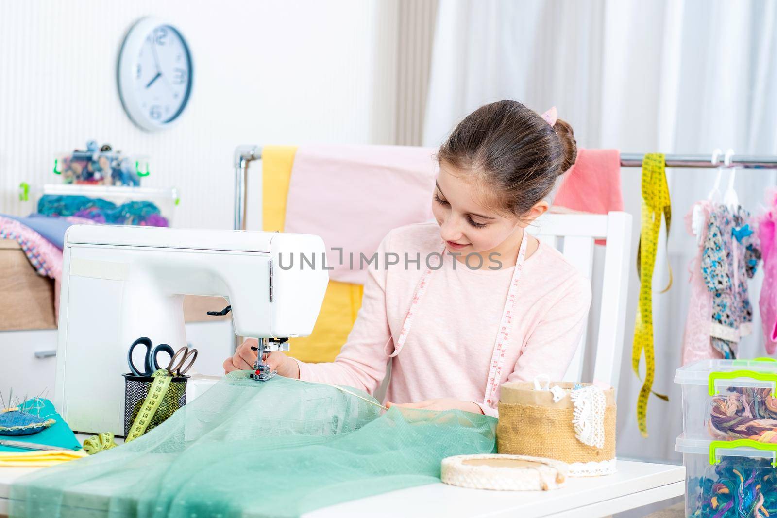 smiling little girl seamstress working at the sewing machine