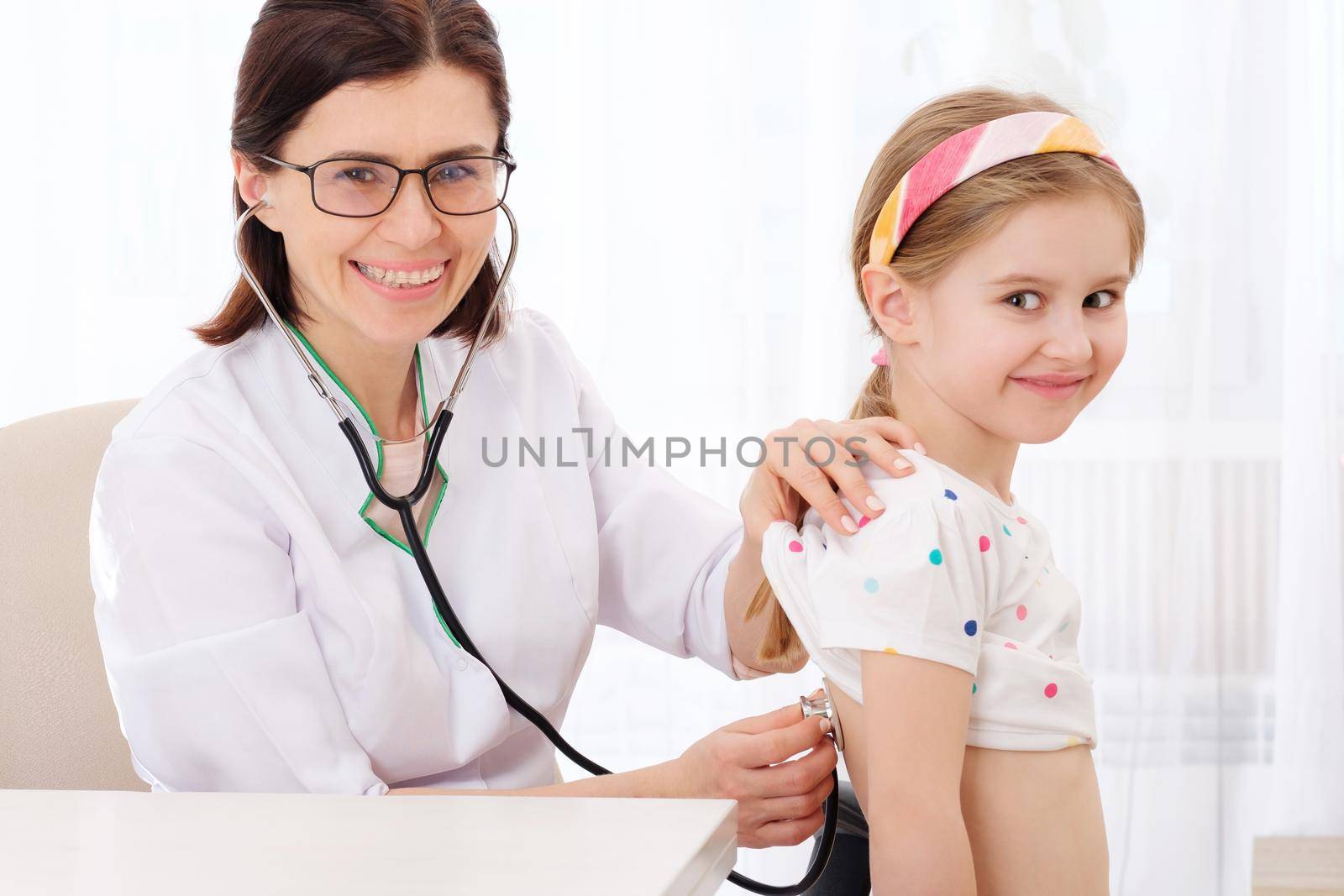 Doctor listening to girl with stethoscope by GekaSkr