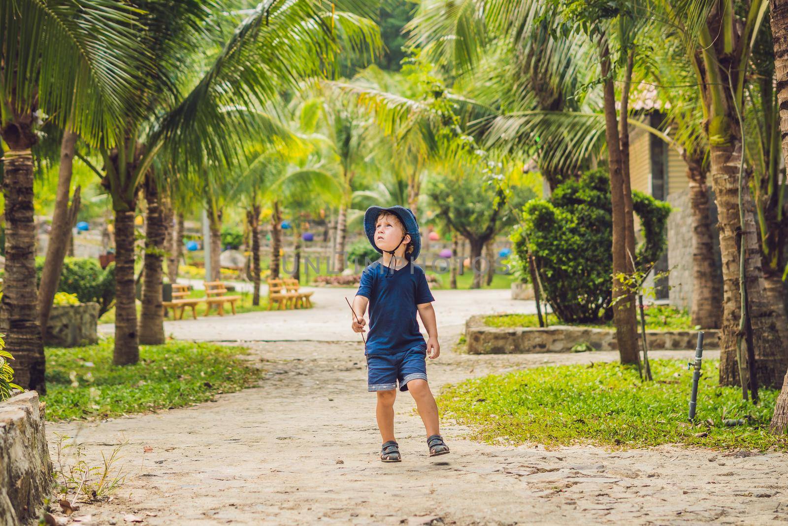 Boy traveler walks in the park in Asia.