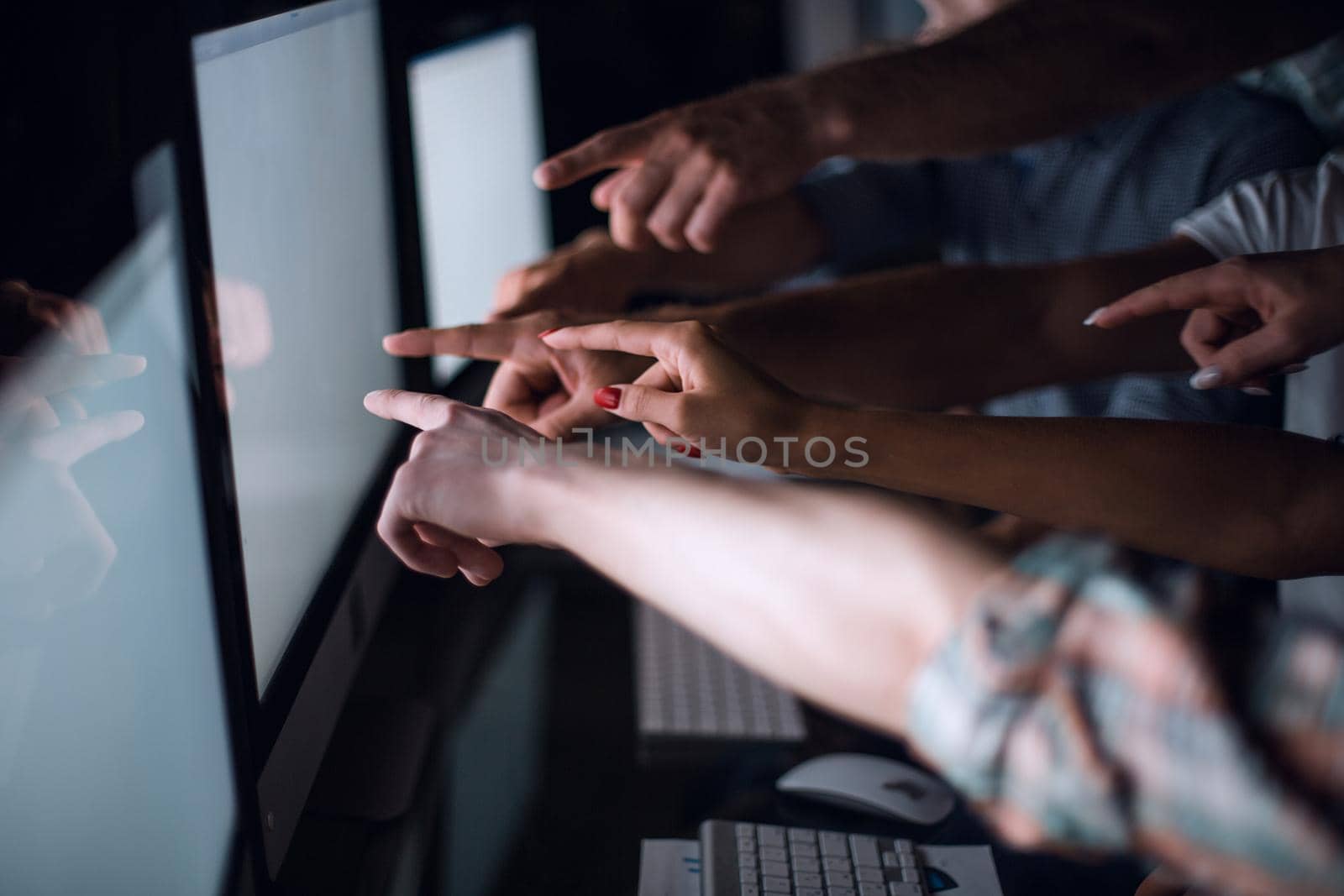 business team is pointing to the monitors of their computers.the concept of teamwork