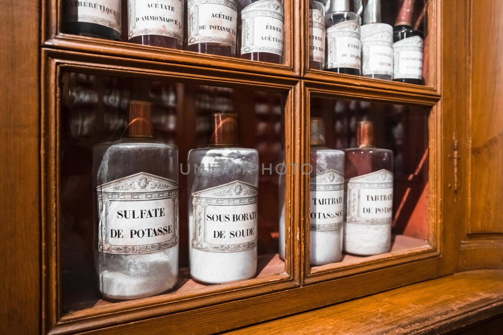 BEAUNE, FRANCE - AUGUST 03,2019: Shelf with medicines in glass bottles in a retro pharmacy