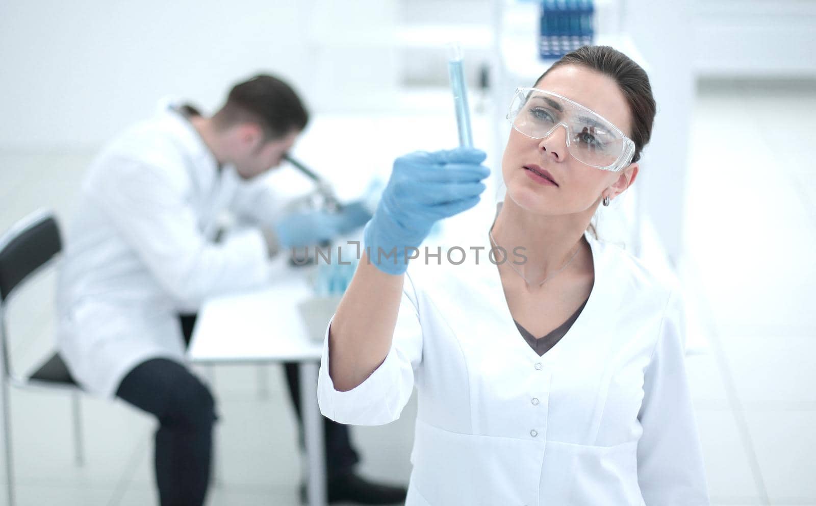 serious female scientist looks at the tube with the results of the analysis.photo with copy space