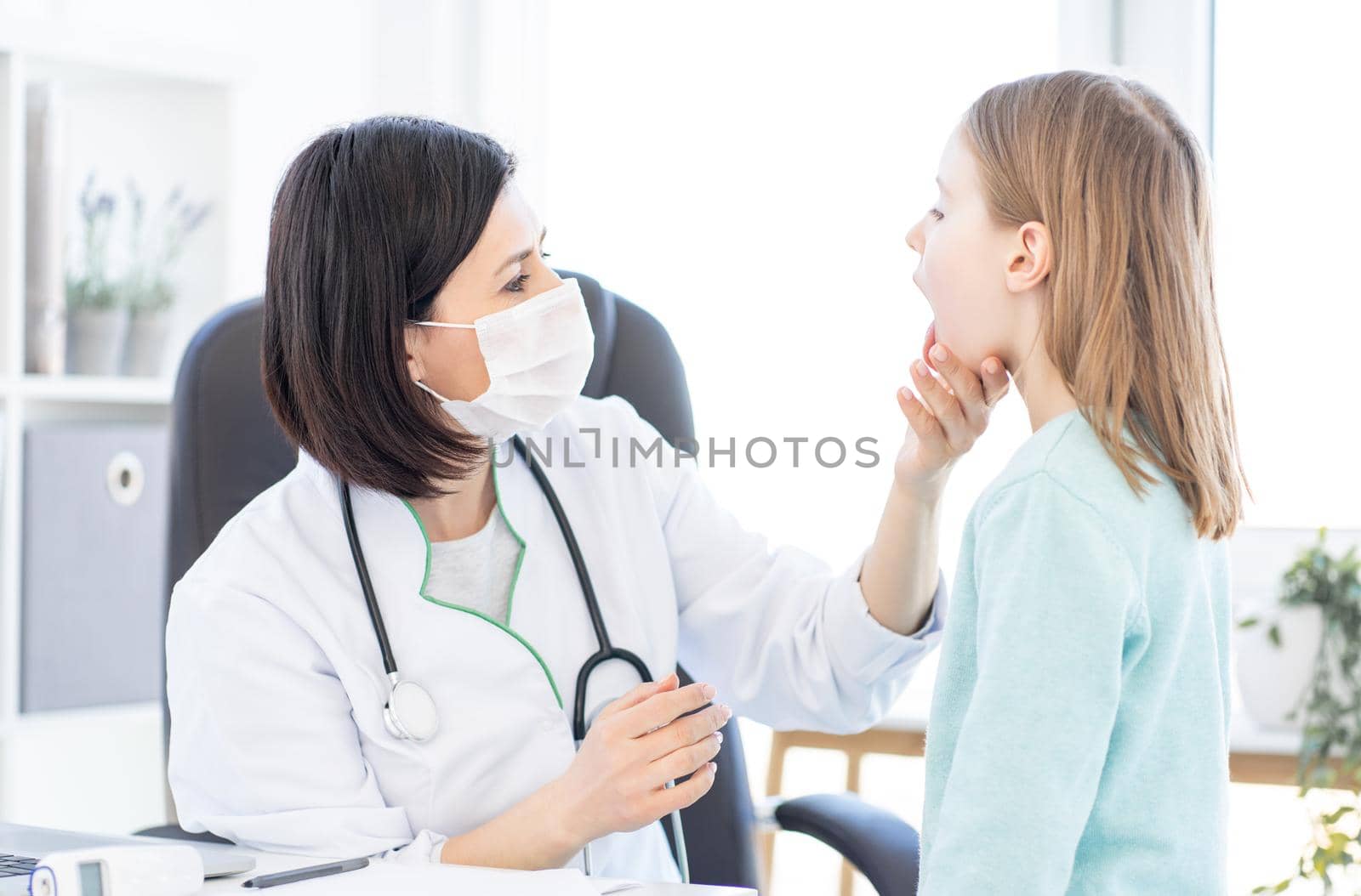 Doctor examining little girl in clinic