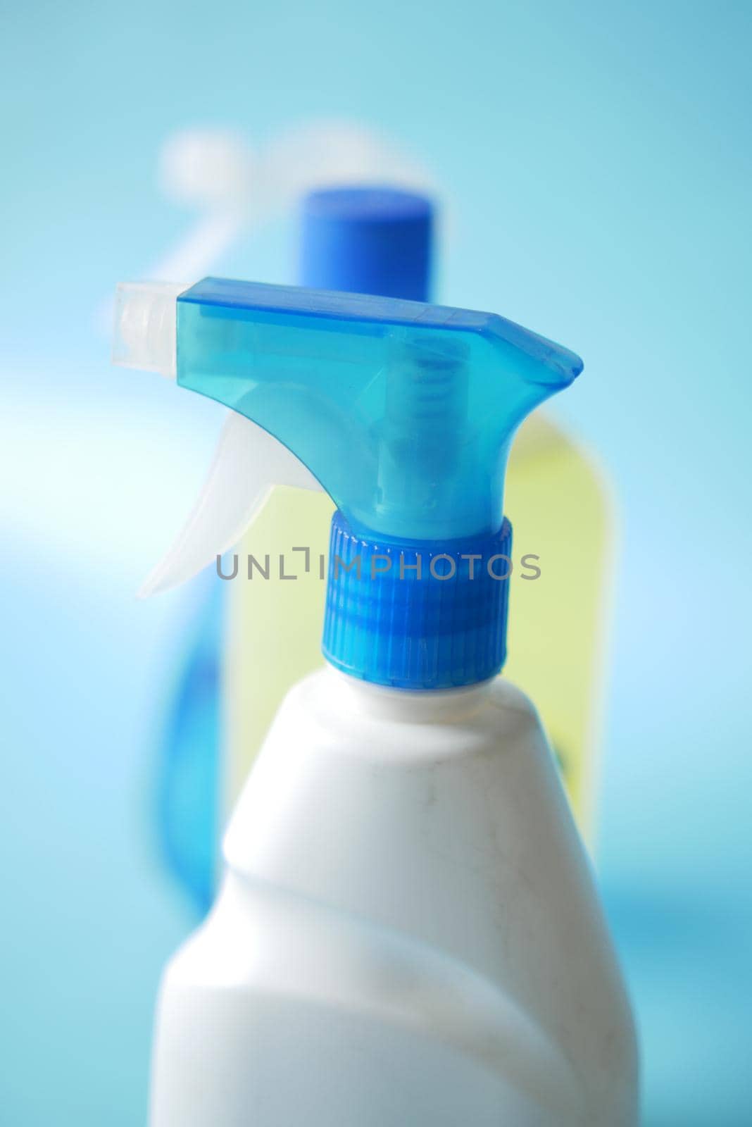 disinfect spray bottles on blue background .