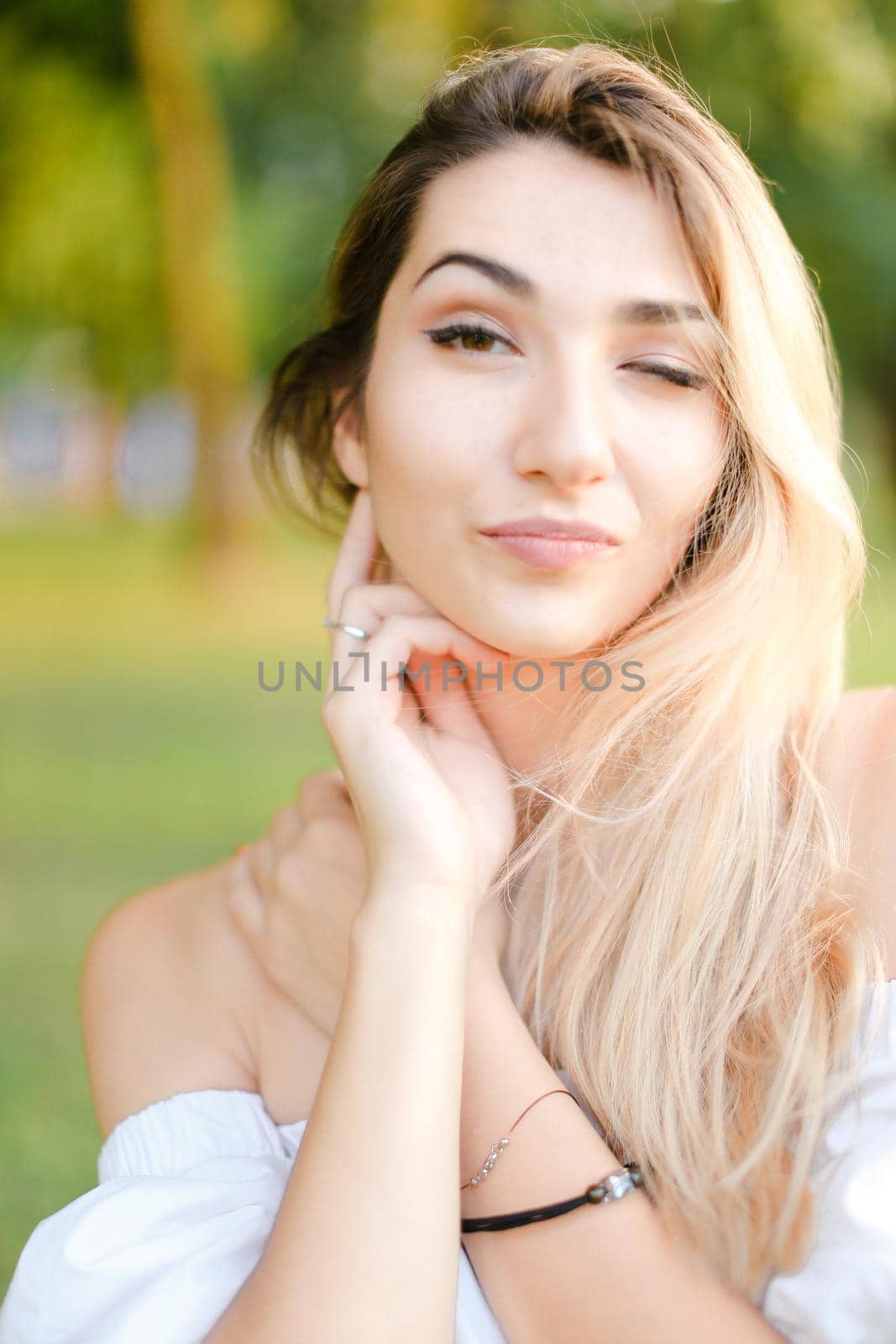 Portrait of young nice female person, green background. Concept of beauty and everyday makeup.