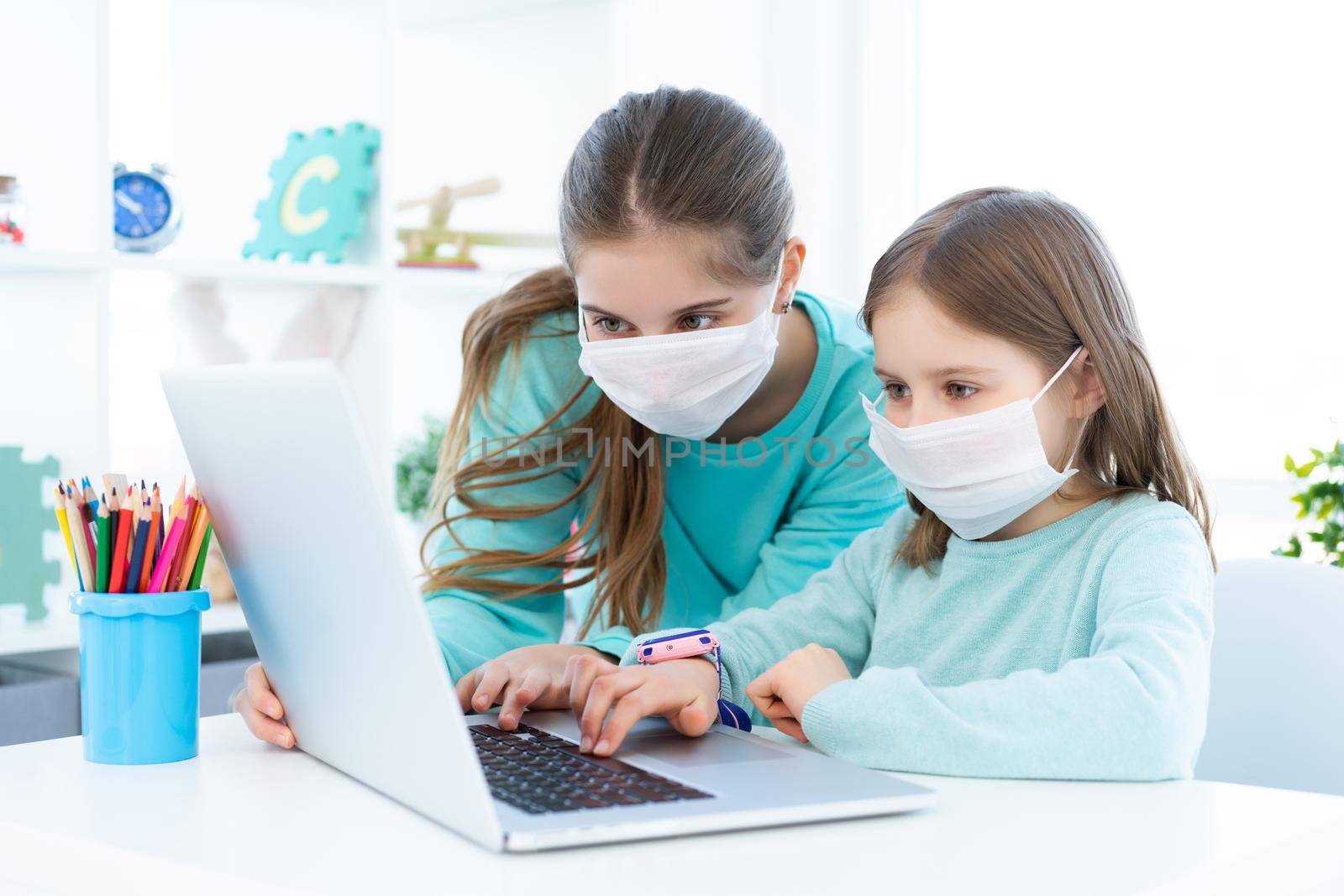 Girls studying at home using laptop during coronavirus pandemic