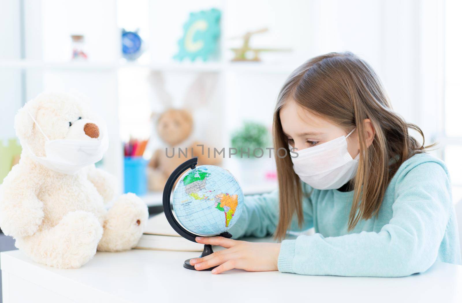 Beautiful school girl with teddy bear studying at home