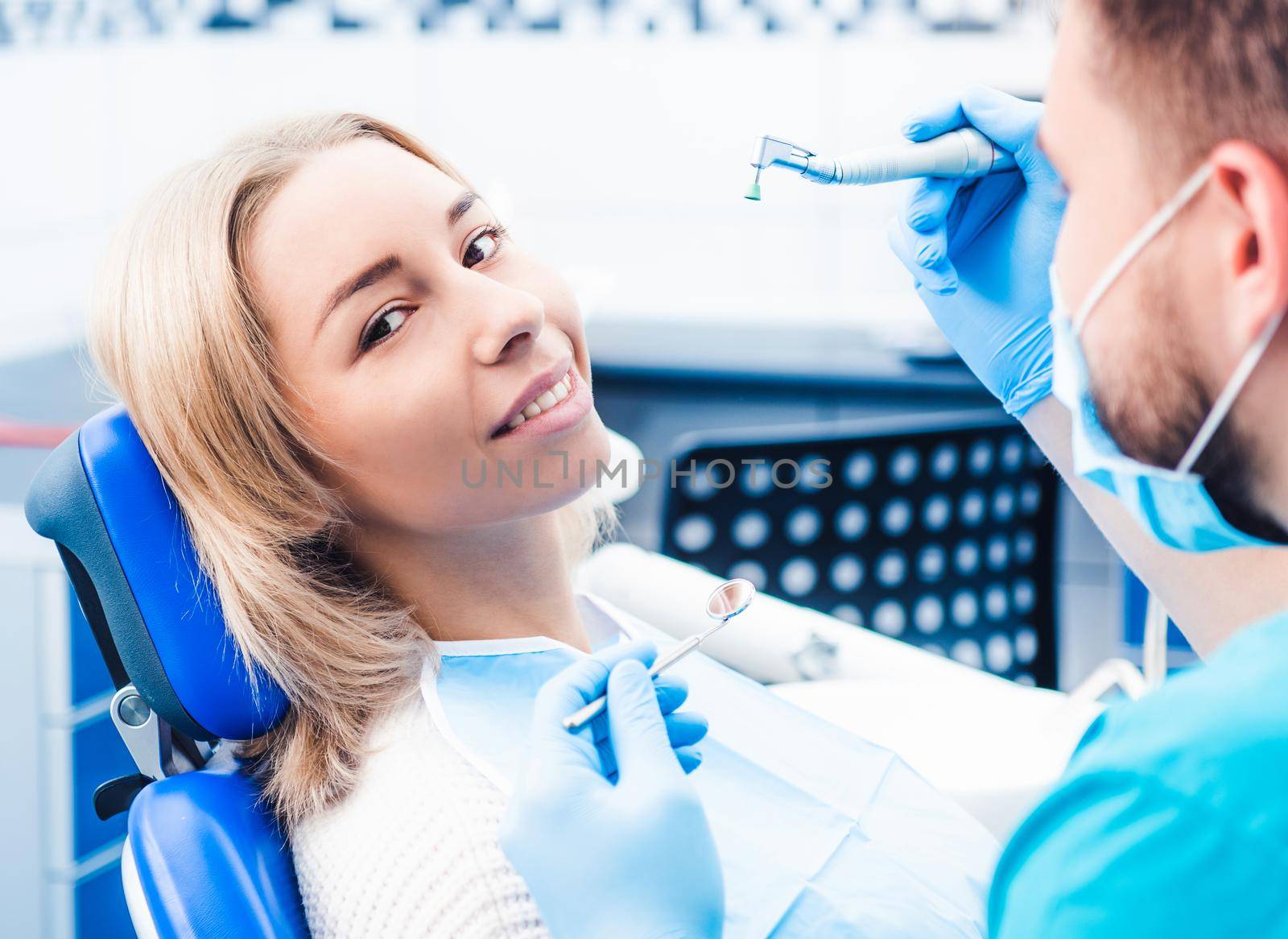 Dentist treating blond smiling girl