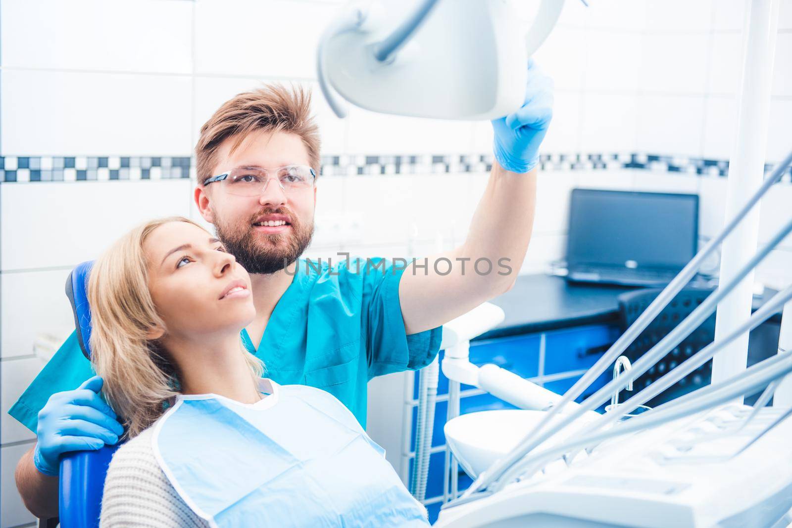 Dentist holding special lamp examinating patient in dentistry