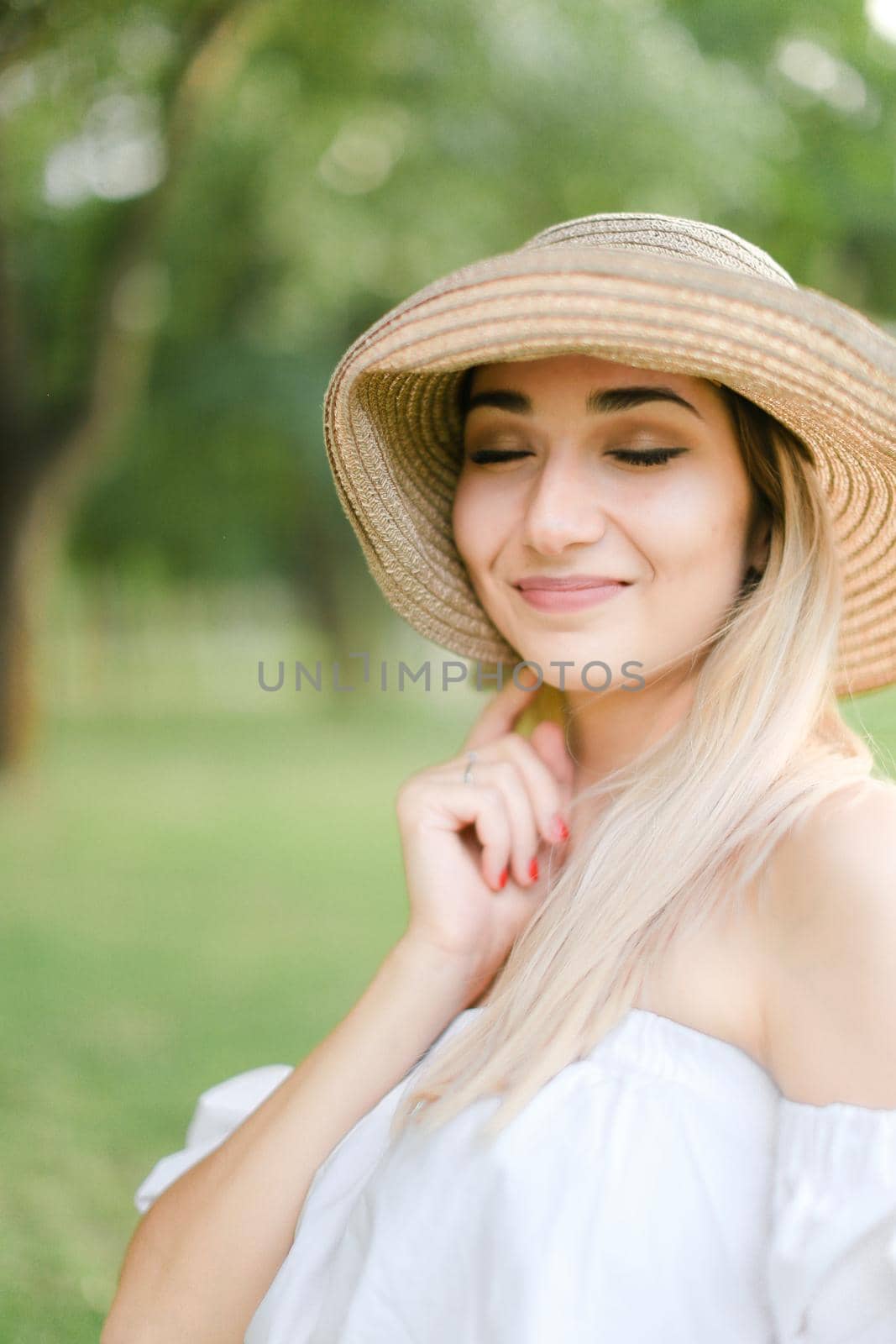 Portrait of young charming caucasian girl wearing hat and smiling. Concept of beauty, female person and summer fashion.