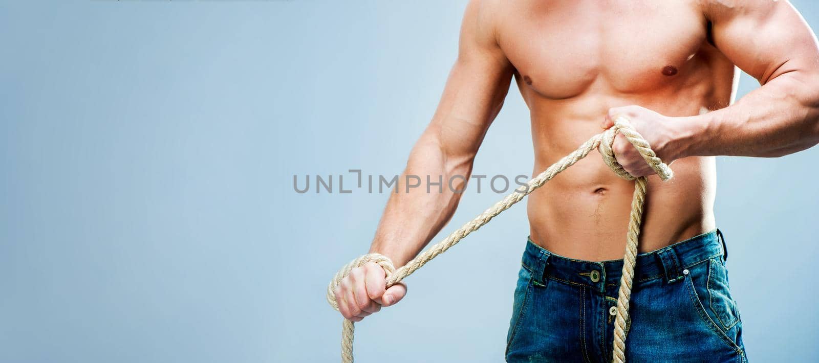 Attractive muscular man body rope breaks with copy space