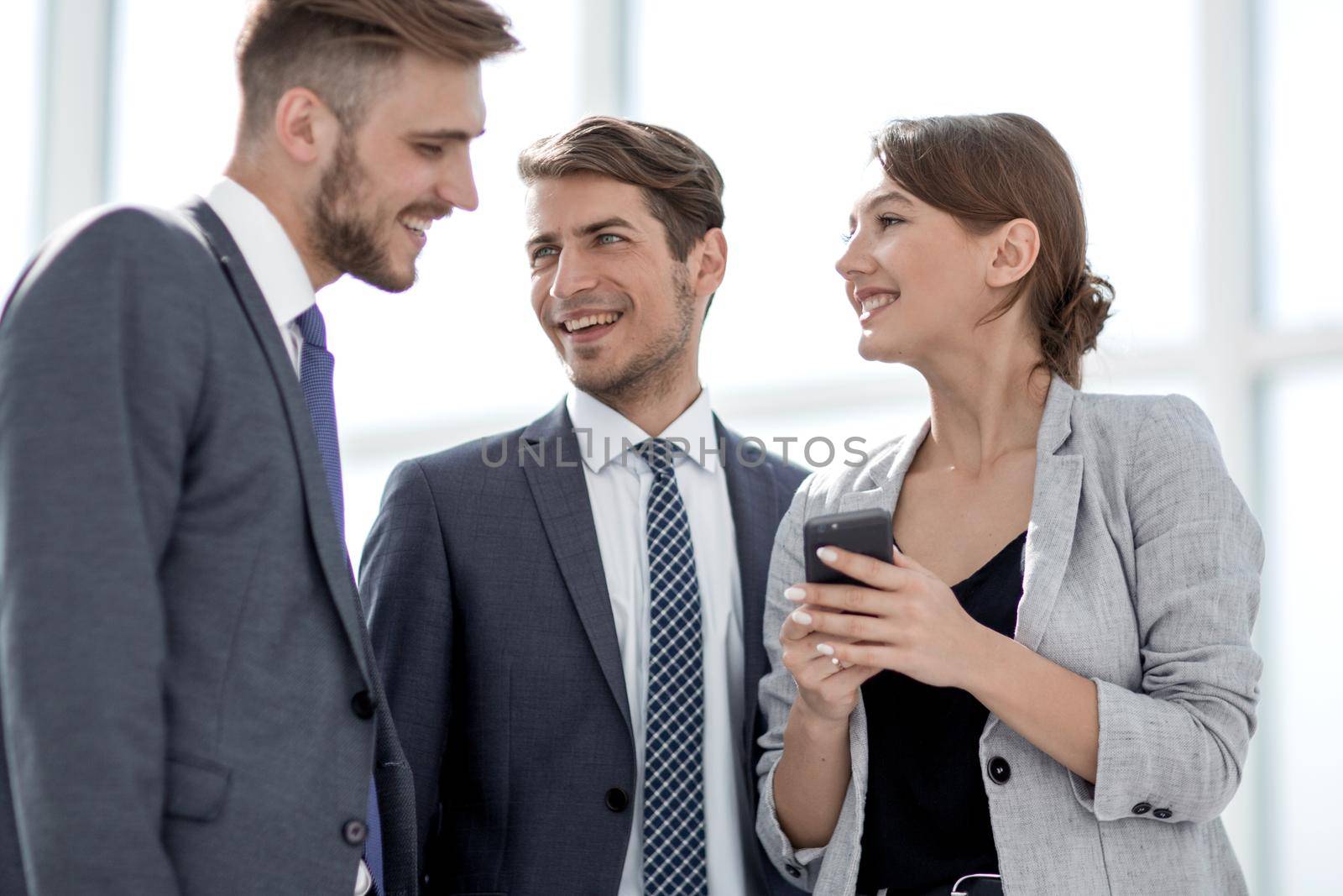 employees of the company standing in the office hall by asdf