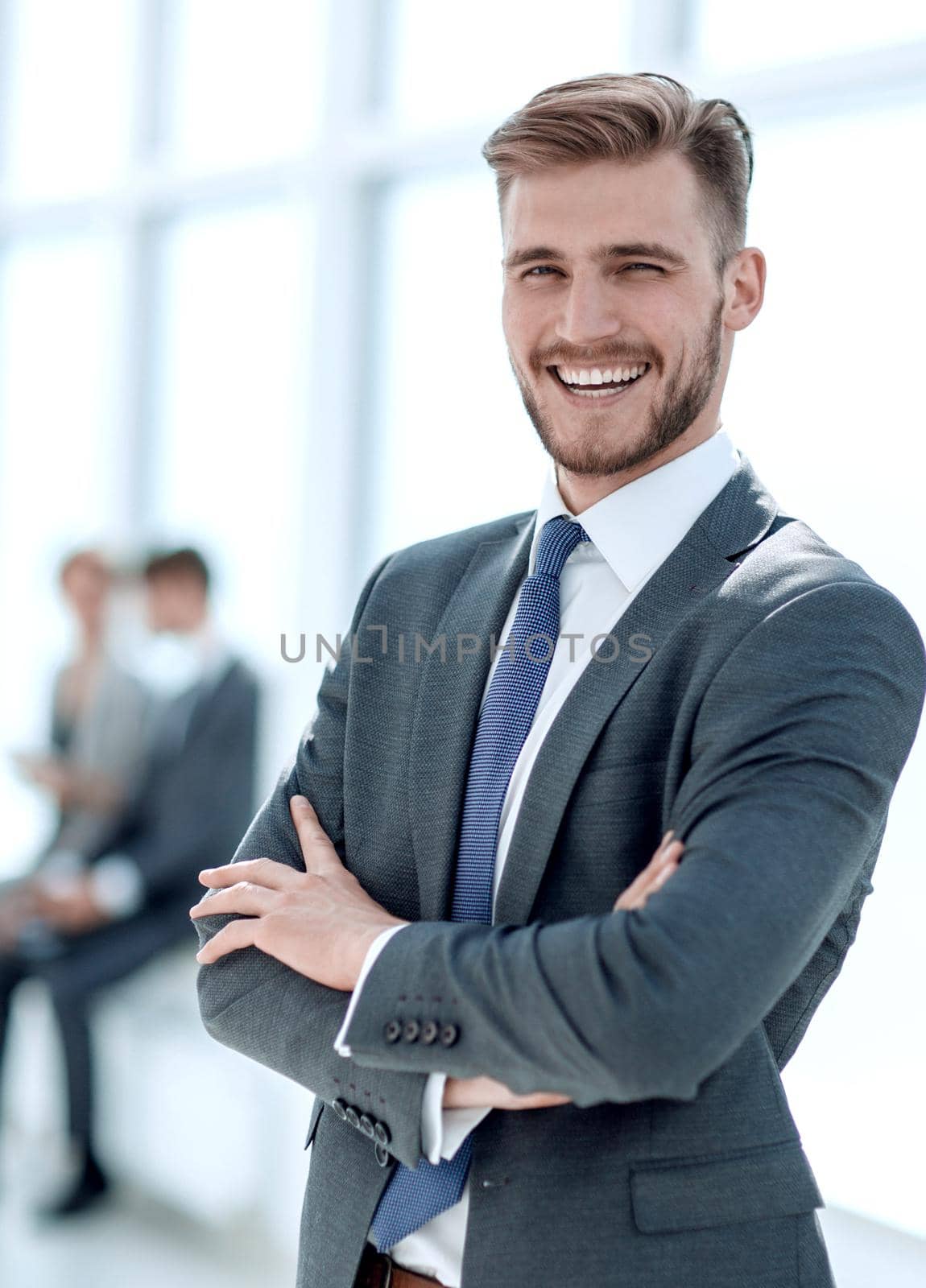 successful businessman on the background of a bright office. by asdf