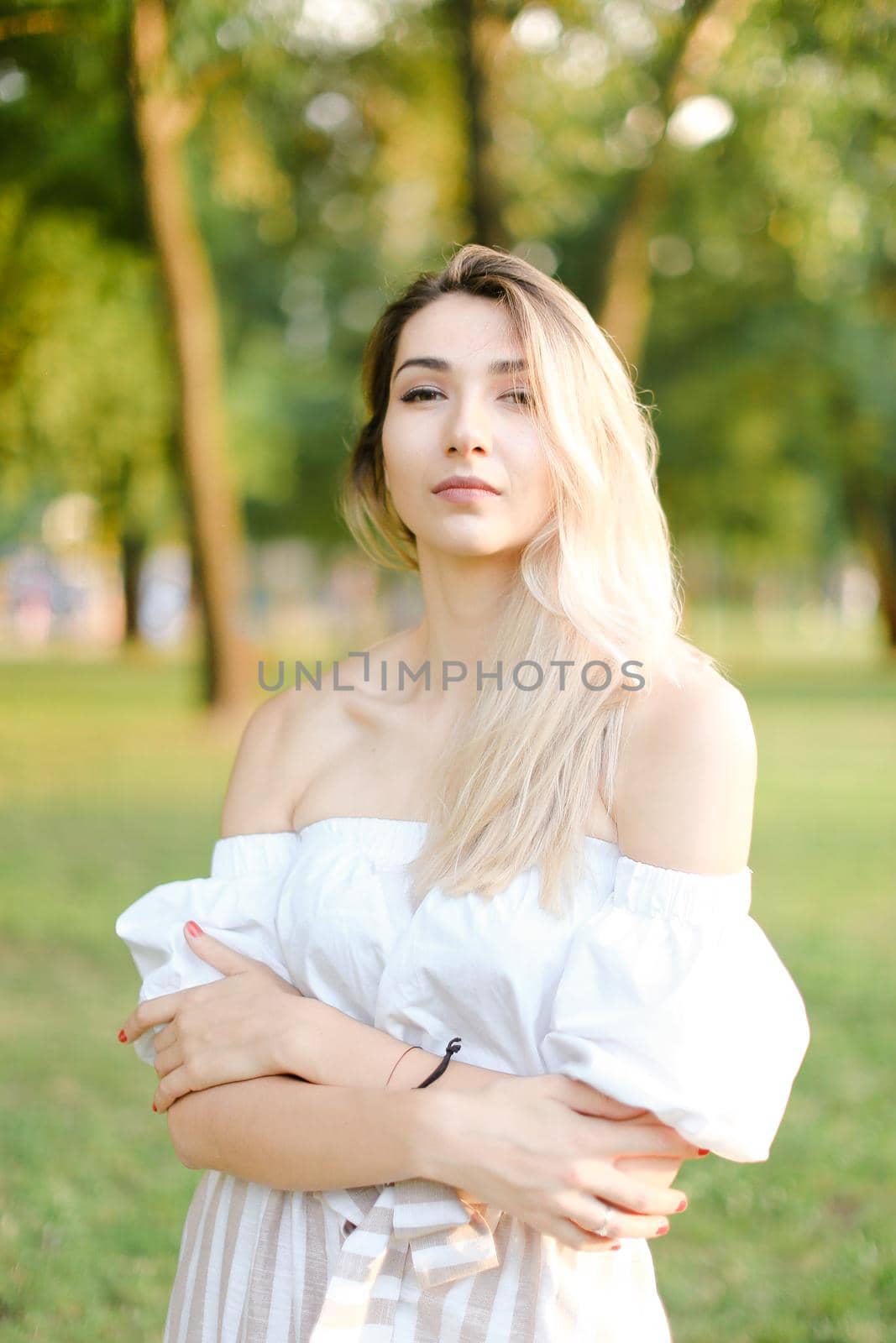 Young blonde girl standing in park. by sisterspro