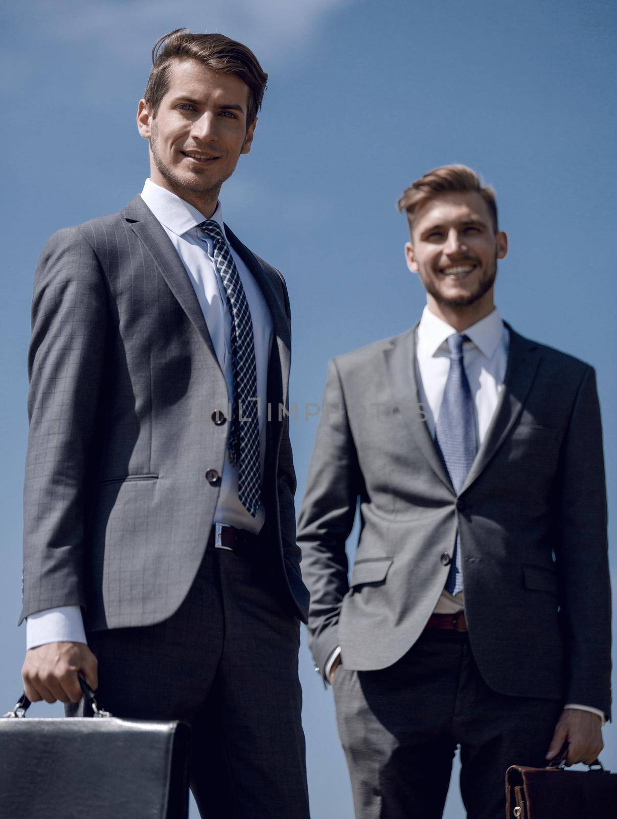 two smiling business men with leather briefcases.concept of cooperation