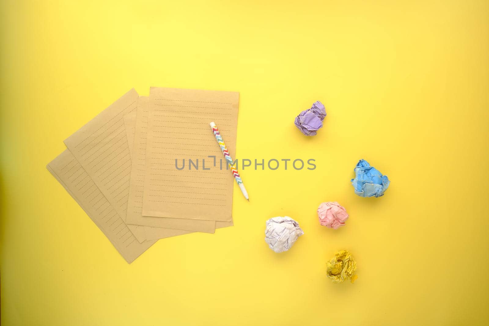 crumpled paper ball and notepad on wooden table