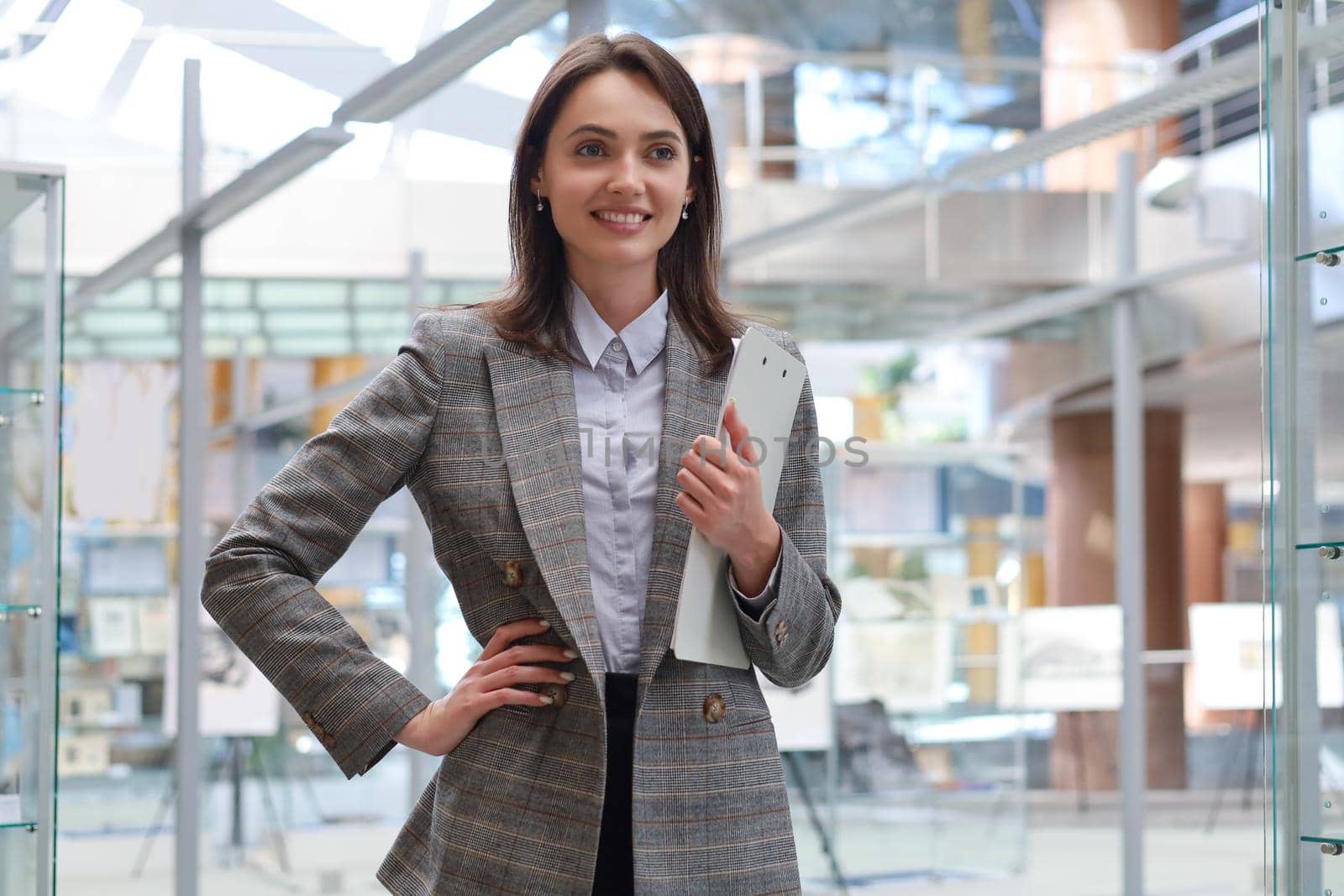 Attractive businesswoman standing in the office area. by tsyhun