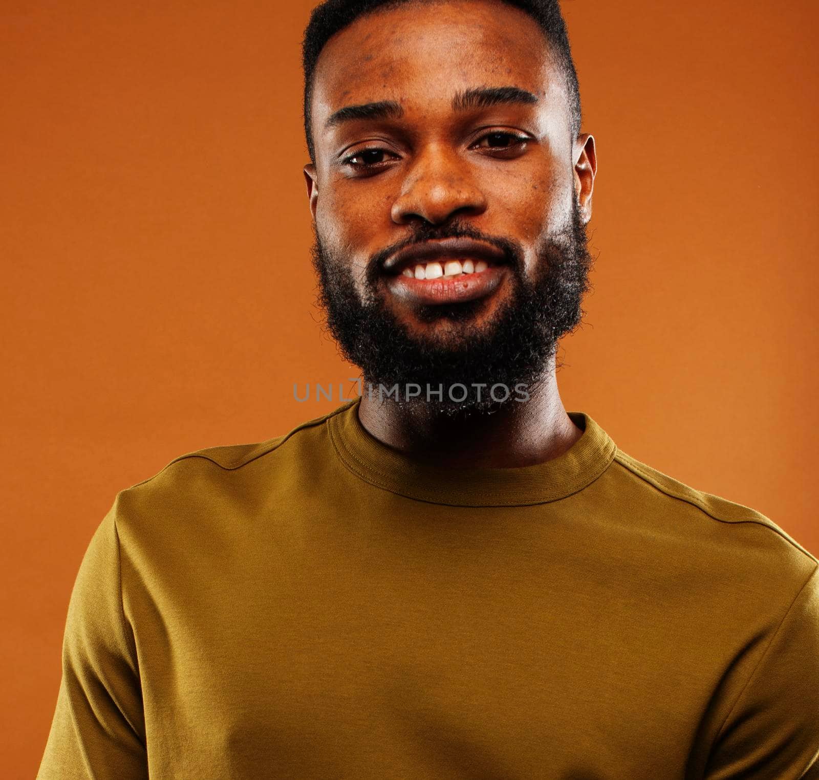 young pretty african american man posing cheerful on brown background, lifestyle people concept close up