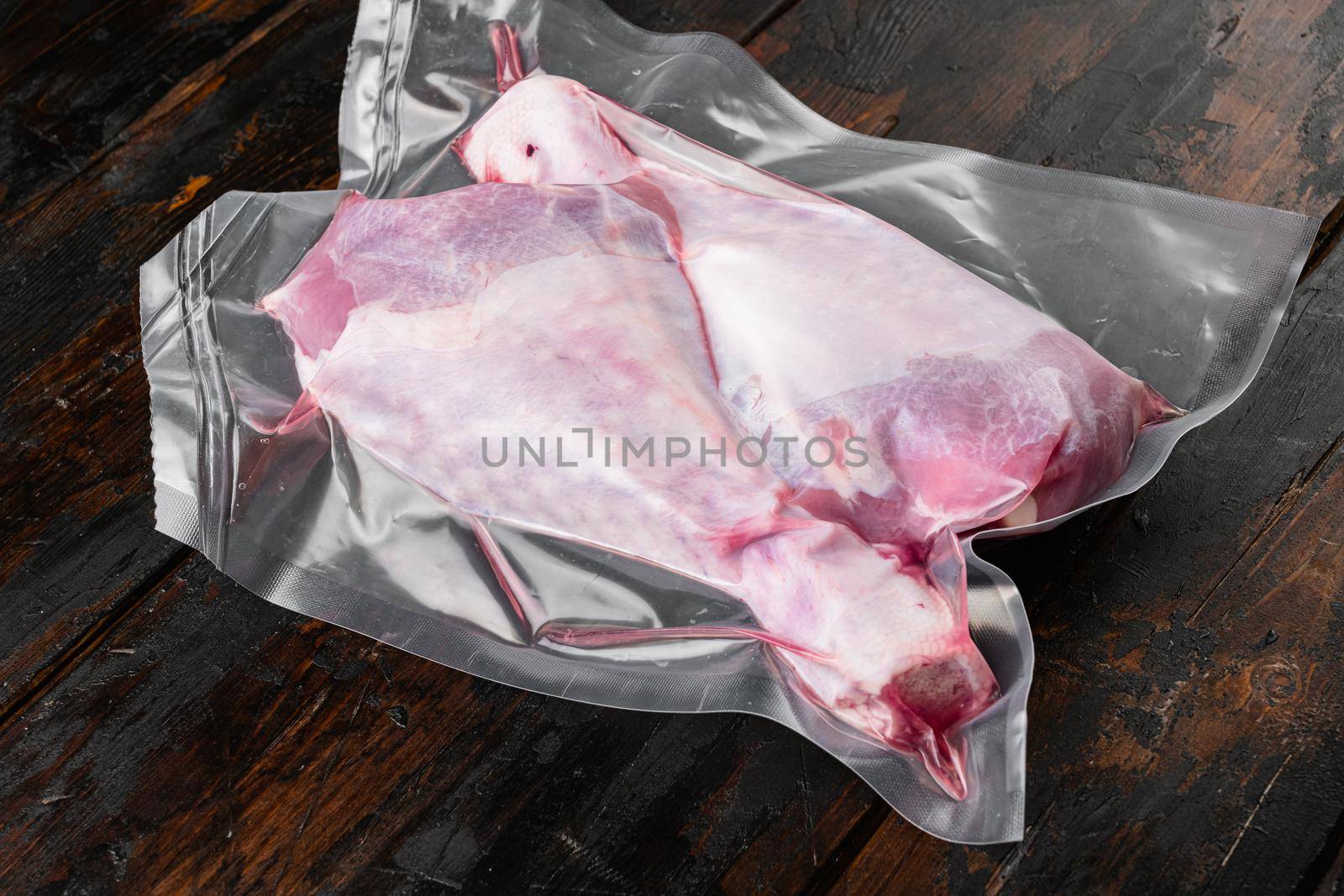 Raw turkey drumsticks and ingredients vacuum pack set, on old dark wooden table background