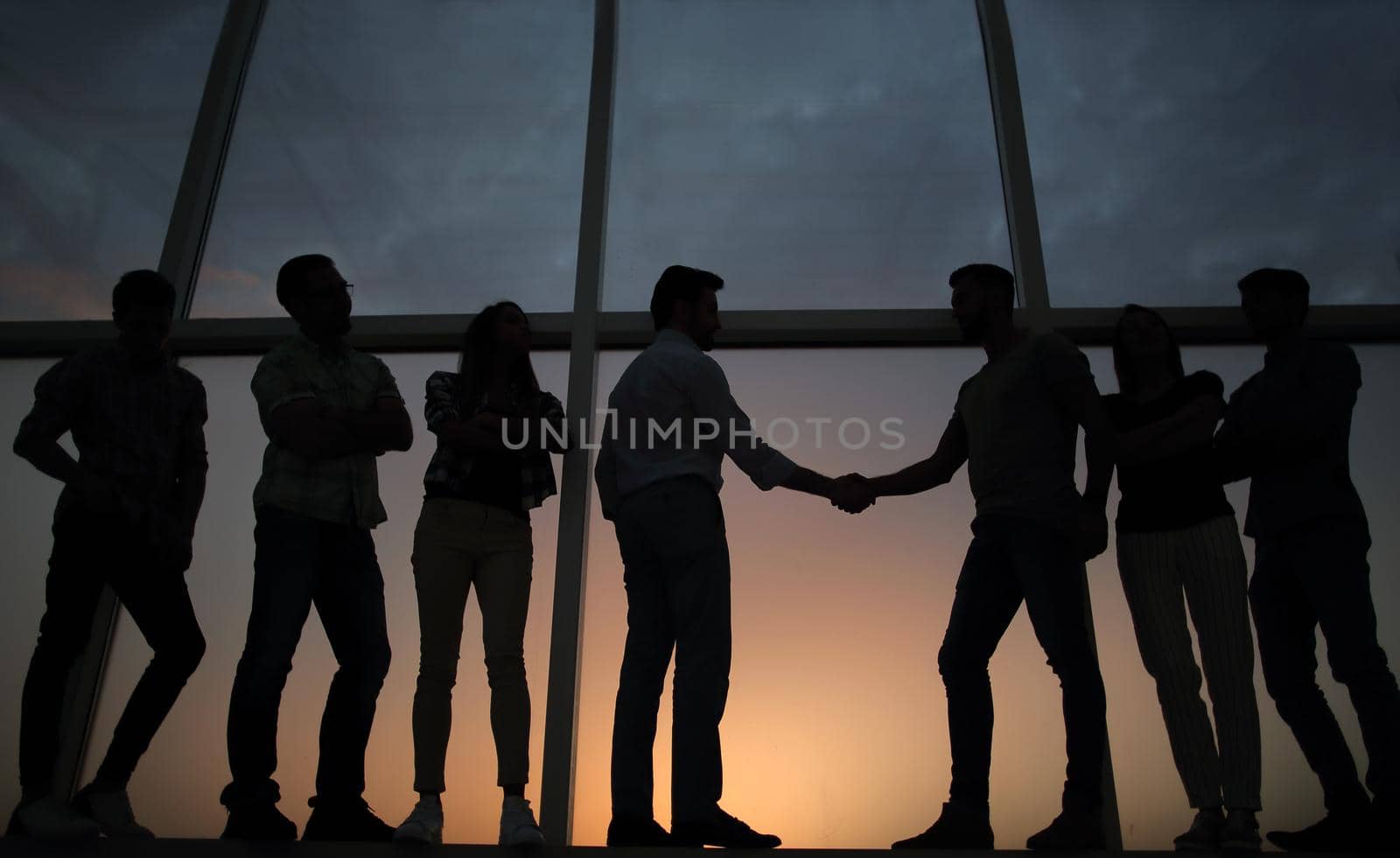 in full growth.handshake of business partners on the background of the office window