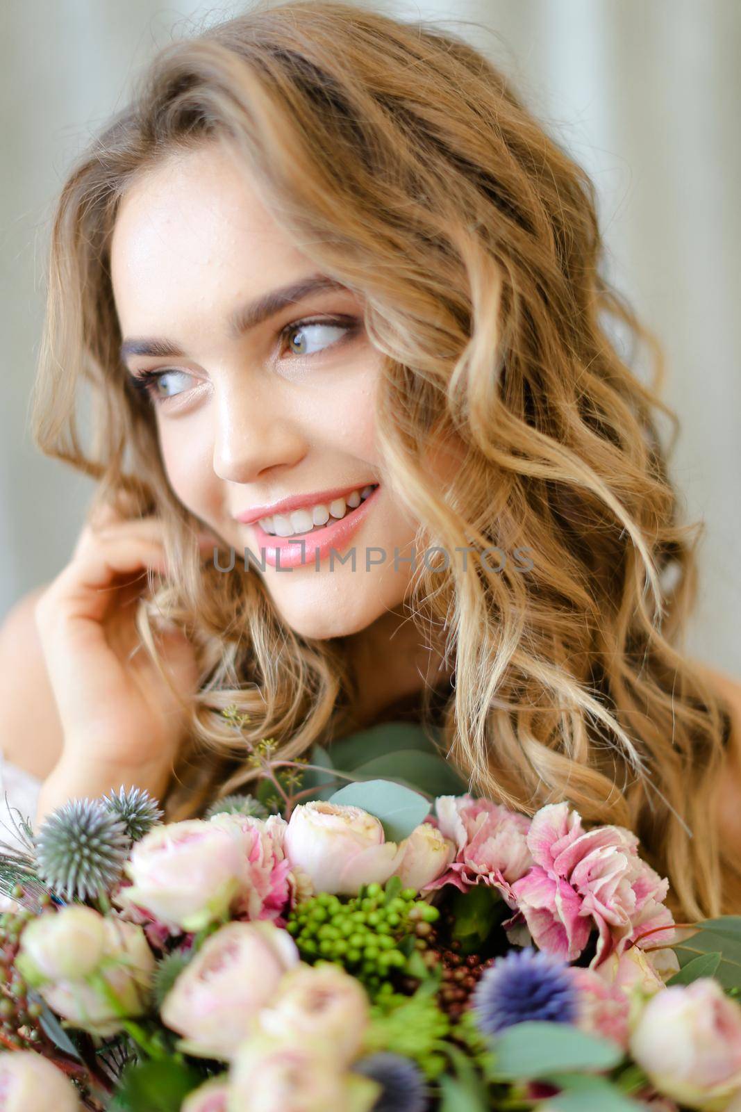 Close up portrait of young caucasian bride with bouquet at studio. Concept of bridal photo session and floristic art.